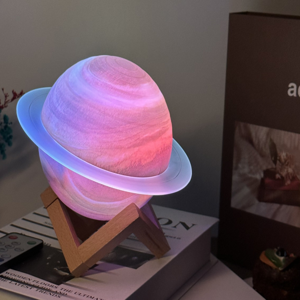Eine planetenförmige Lampe mit Holzsockel auf einem Bücherstapel.