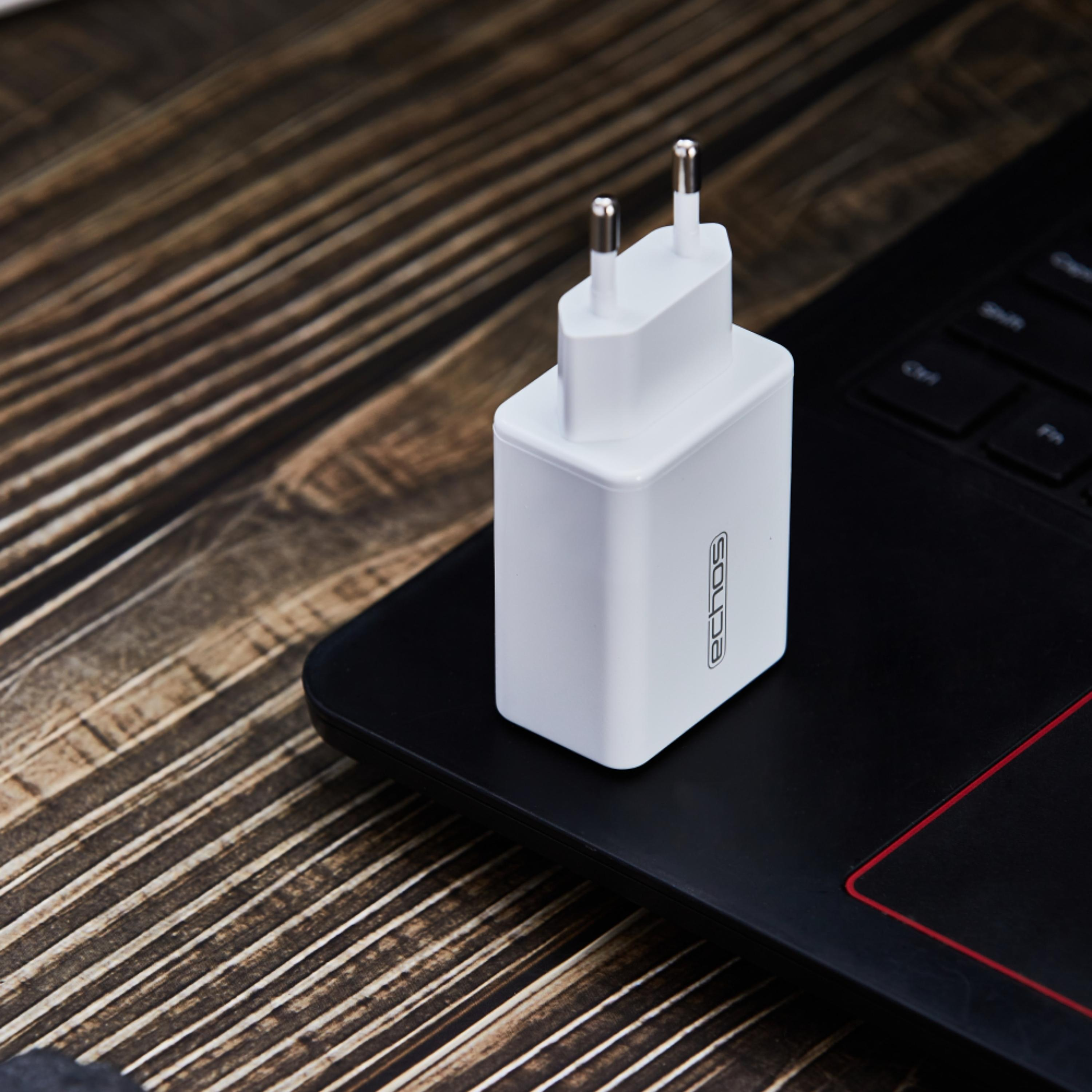 Ein weißer Netzadapter auf einem Laptop. Der Adapter hat das Wort 'echos' darauf.