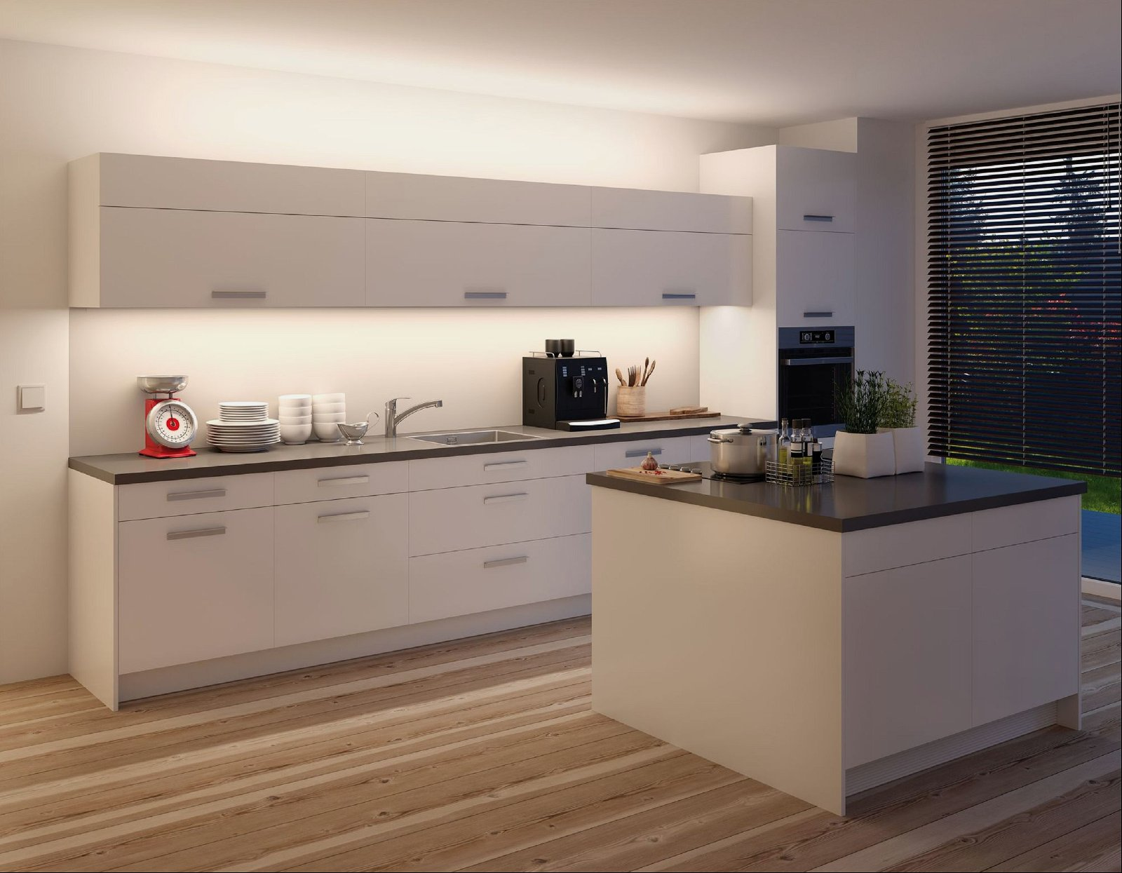 Nowoczesna kuchnia z białymi szafkami, ciemnym blatem i małą czerwoną wagą.