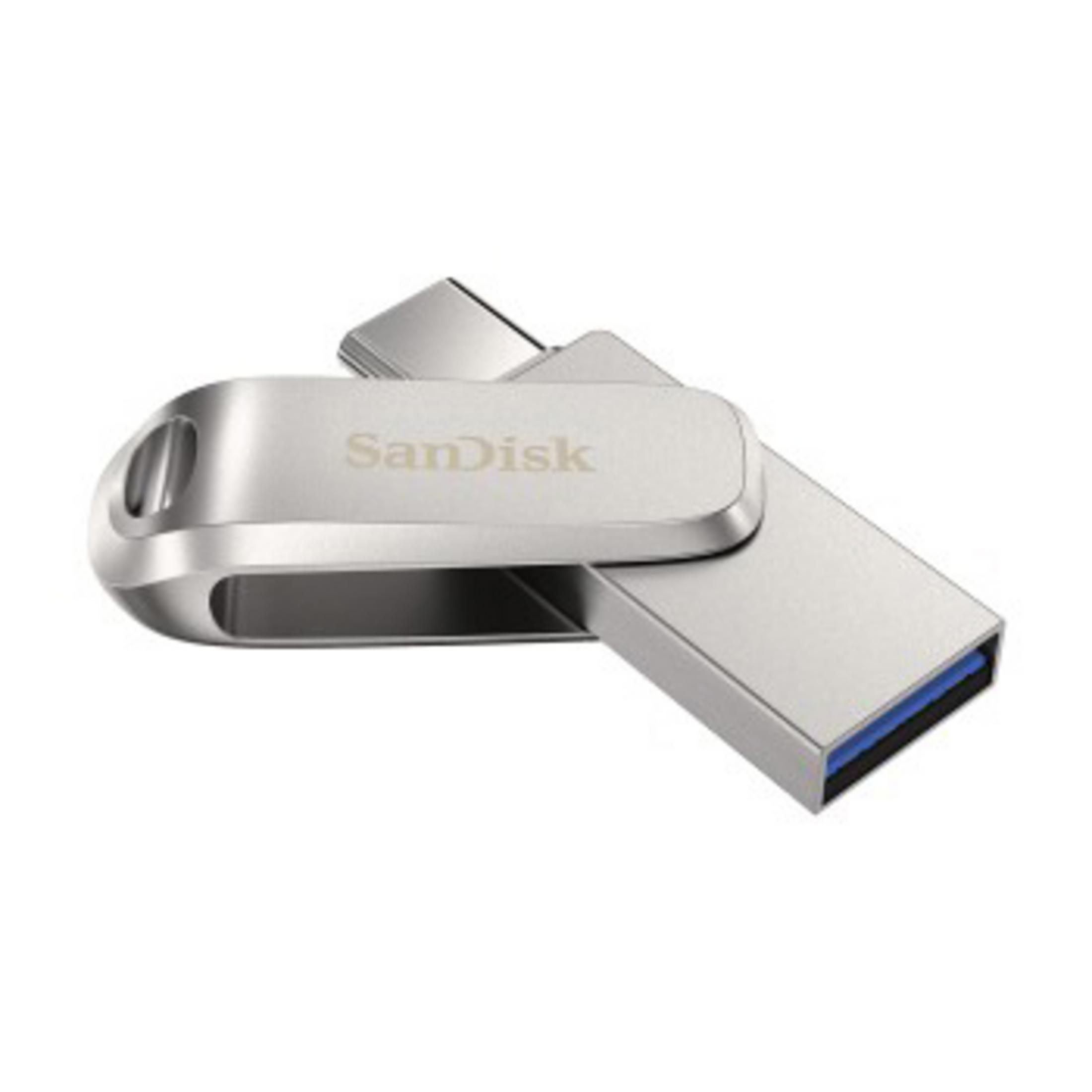 Srebrny pendrive SanDisk. Pendrive ma srebrną metalową obudowę i złącze USB.