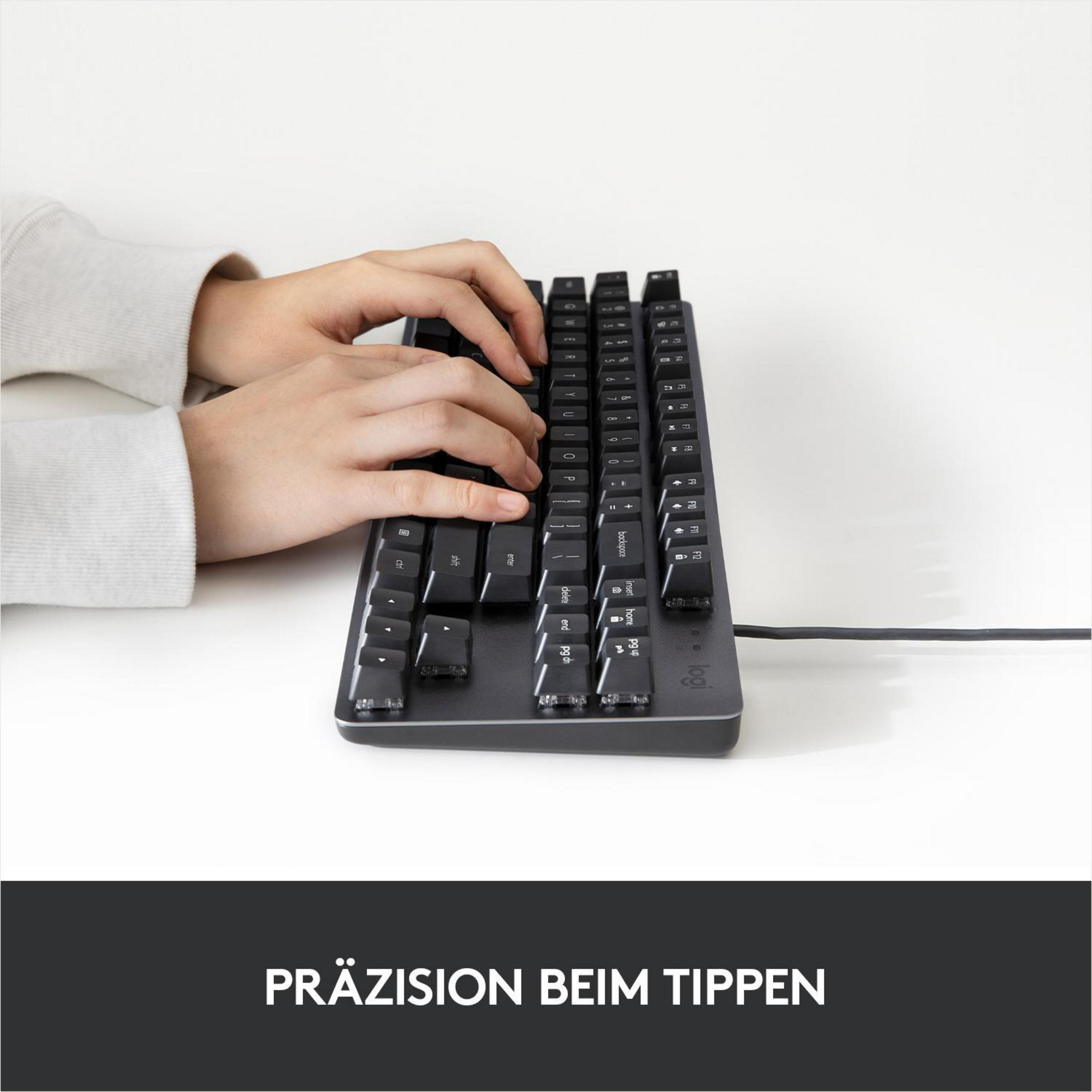 Mani che digitano su una tastiera nera. Il testo sottostante dice 'Präzision beim Tippen'.