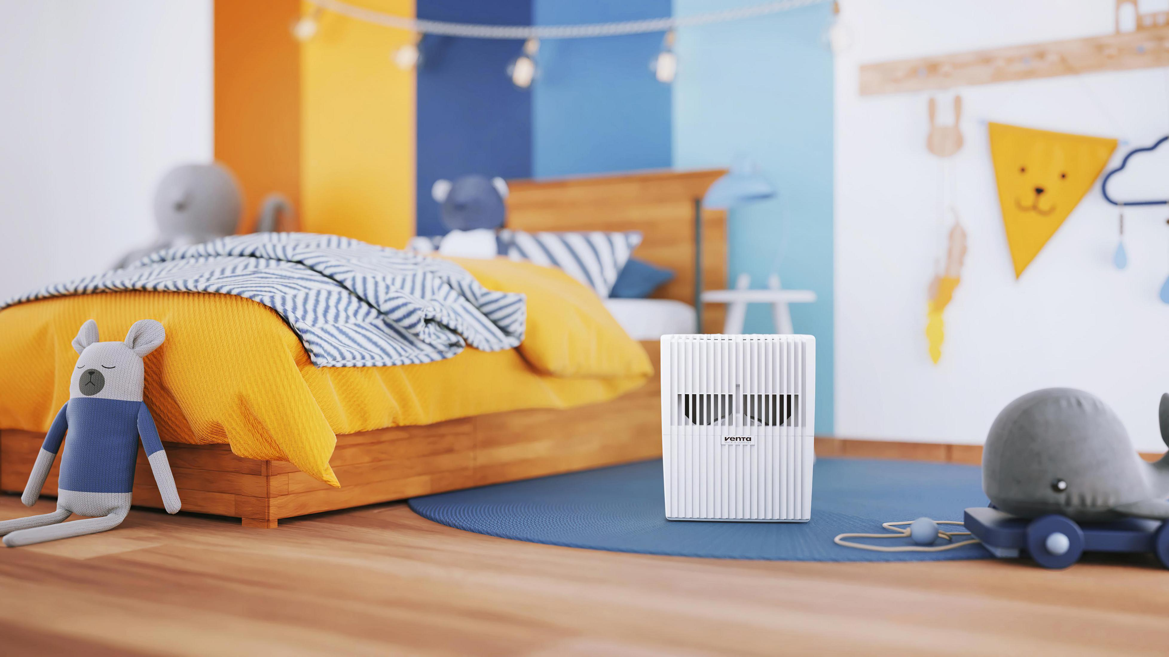 Una camera da letto con un letto, una balena giocattolo e un purificatore d'aria bianco.