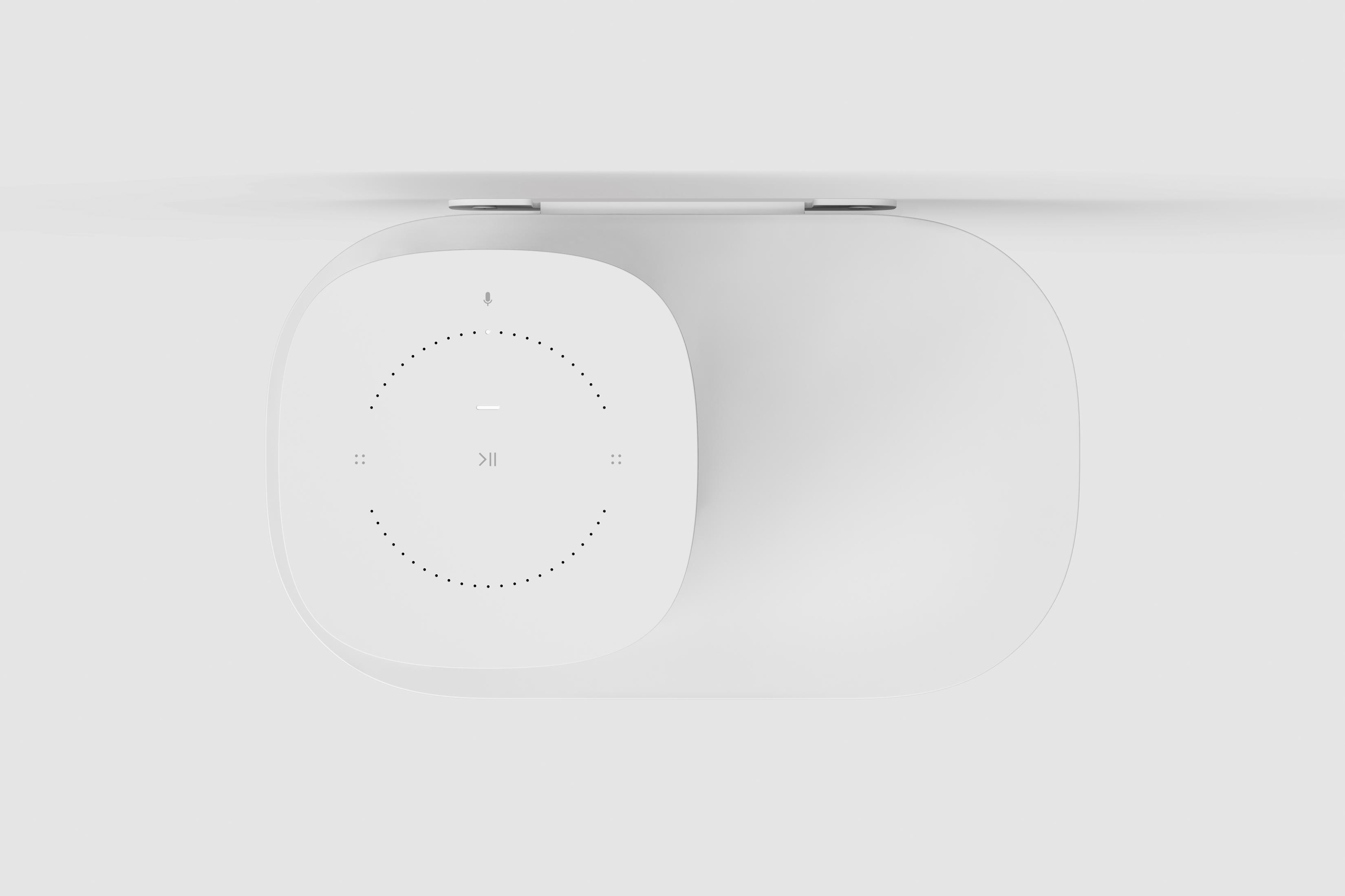 Un altavoz/dispositivo blanco, vista superior. Tiene un panel de botones en un lado y una rejilla de altavoz.