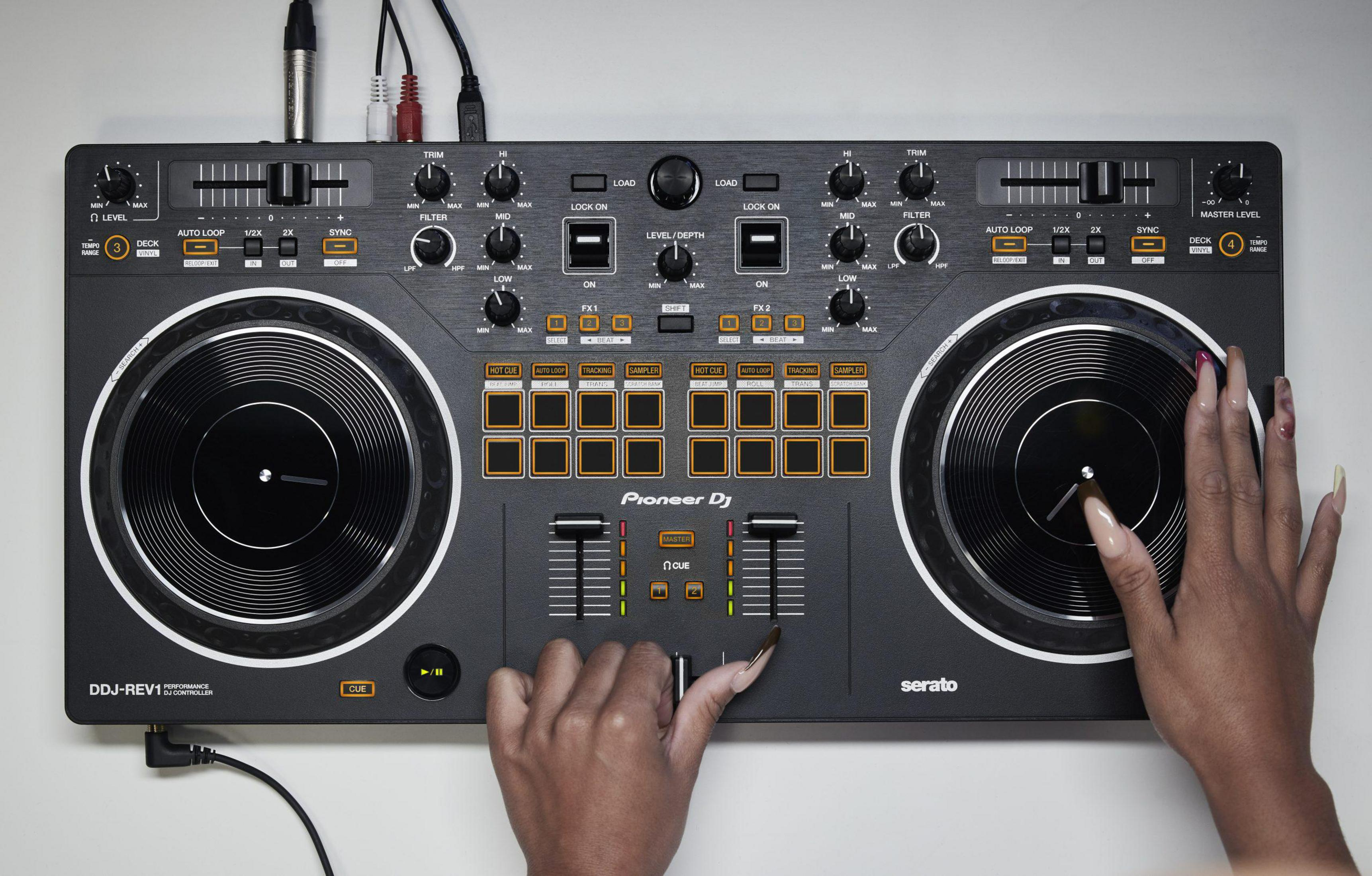 Ein DJ-Controller mit zwei Plattenspielern und Händen, die Knöpfe einstellen. Draufsicht.