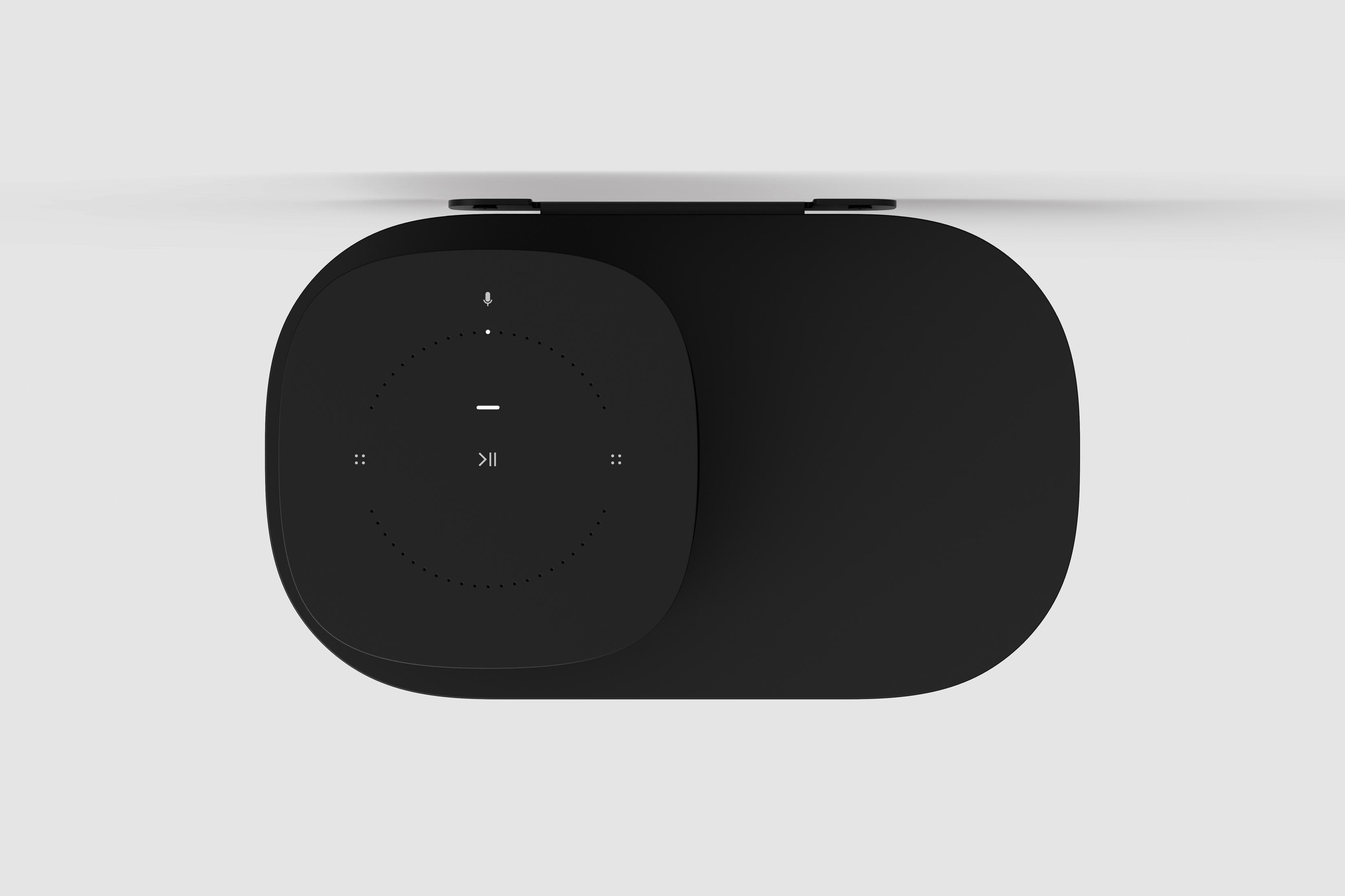 Altavoz negro con panel táctil en la parte superior. Tiene un diseño minimalista y un fondo blanco.