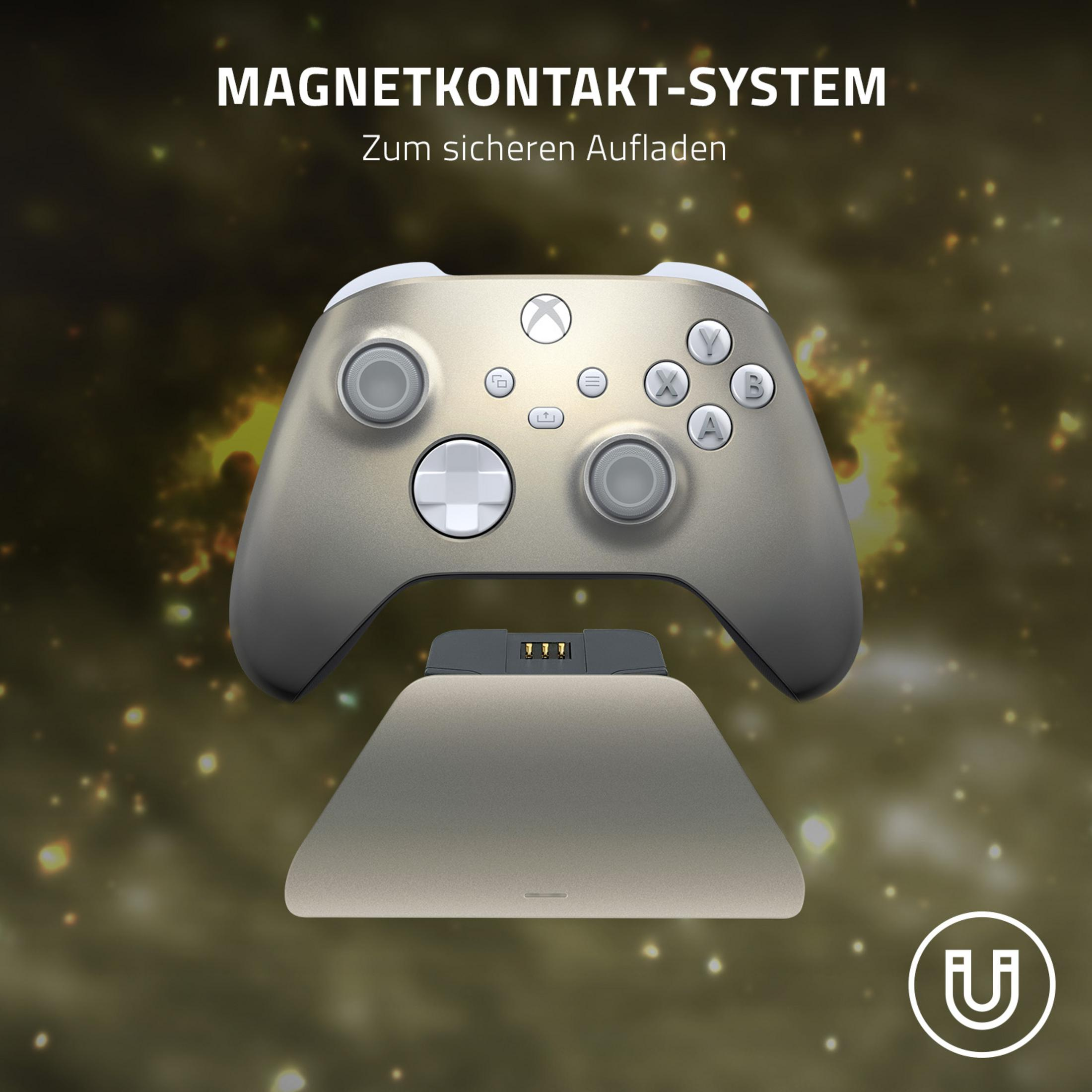 Un controller di gioco argento-oro su una base di ricarica, con un sistema di ricarica magnetico visualizzato.