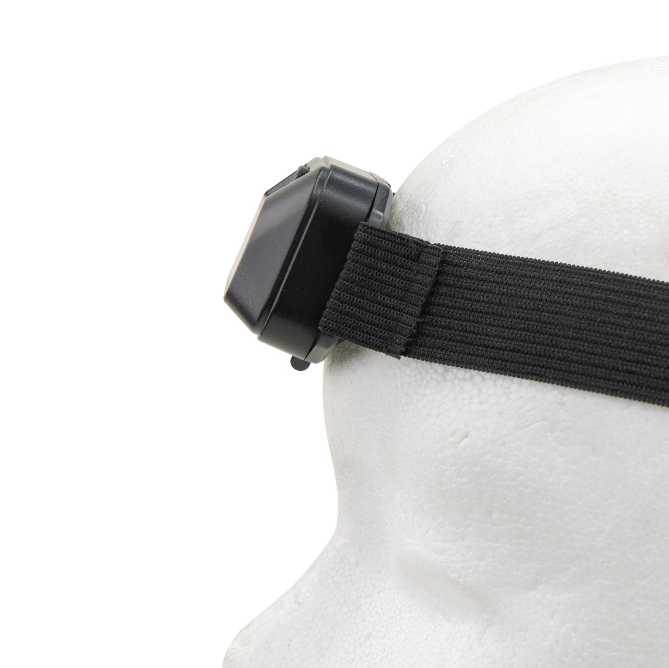 Eine schwarze Stirnlampe auf einem weißen Styroporkopf, die das Band und die Leuchteinheit zeigt.