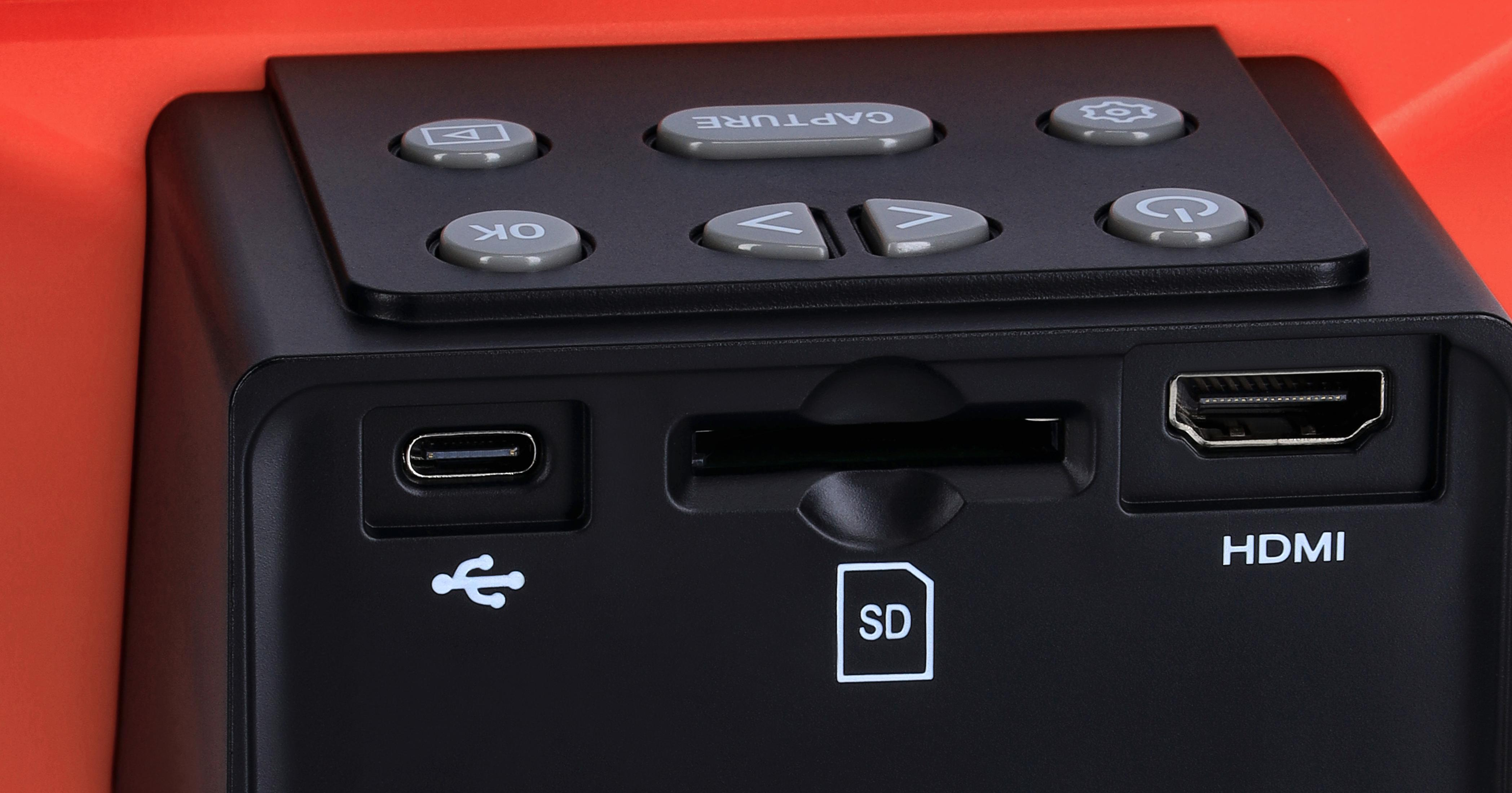 Nahaufnahme eines schwarzen Scanners mit mehreren Anschlüssen und Knöpfen. Der Hintergrund ist orange.