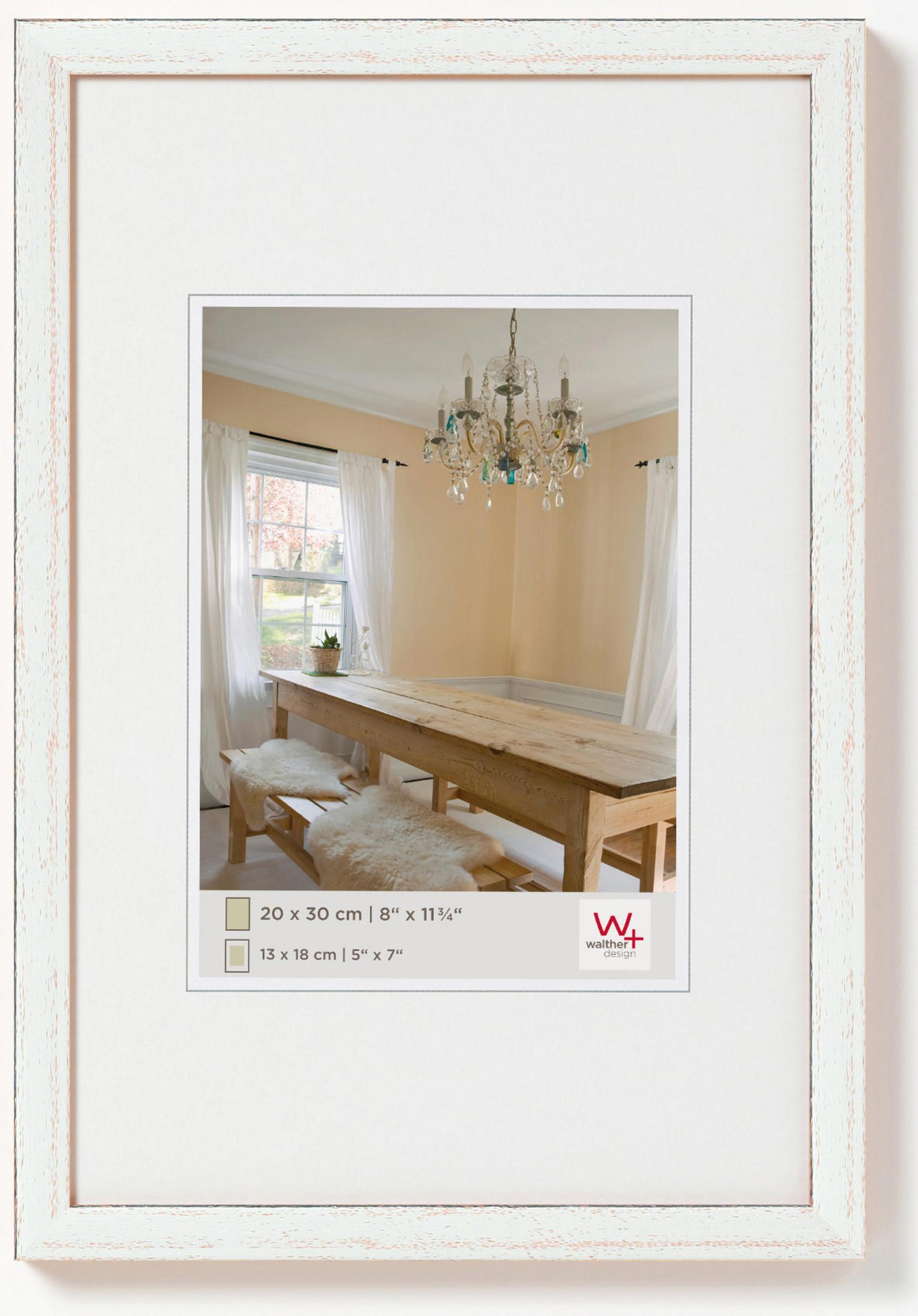 Weiß gerahmtes Bild mit Esszimmer-Szene. Tisch, Stühle und Kronleuchter sichtbar.