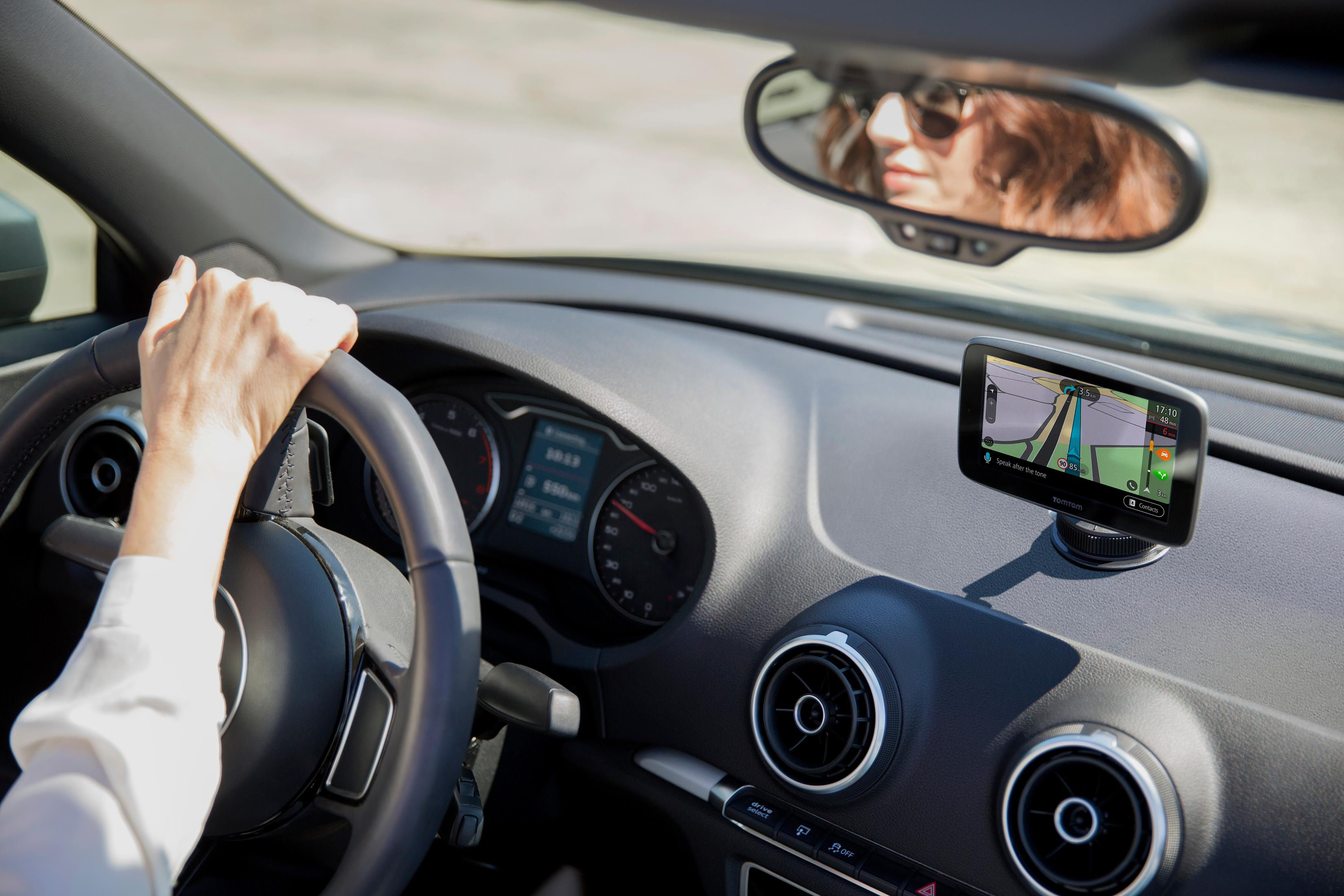 Frau fährt Auto, Hände am Lenkrad, GPS auf dem Armaturenbrett.