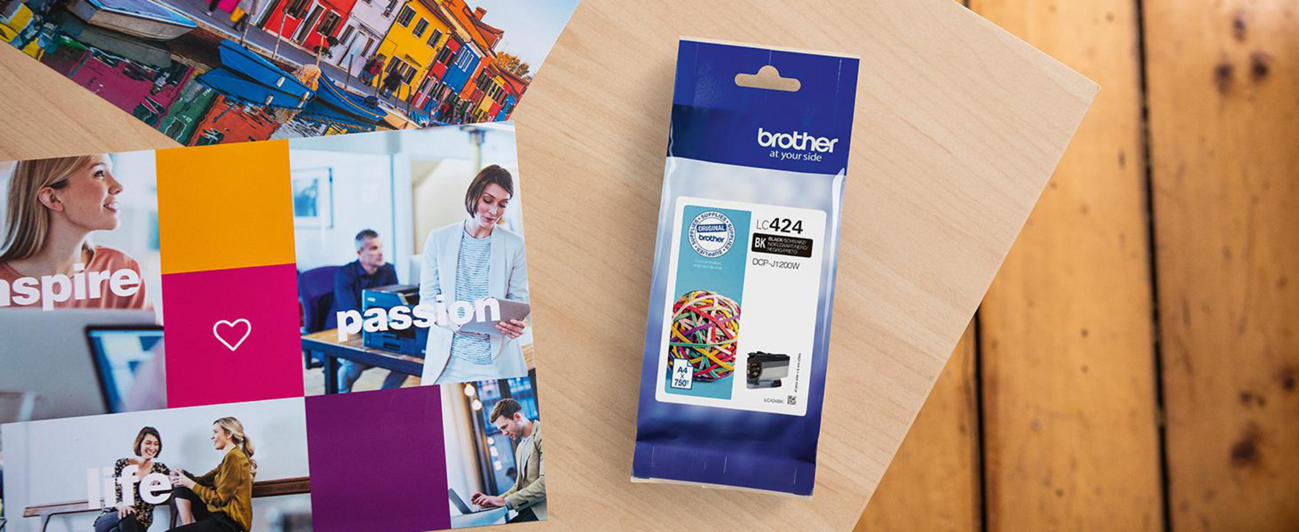 Wkład atramentowy Brother w plastikowym opakowaniu, w pobliżu zdjęć i drewna.