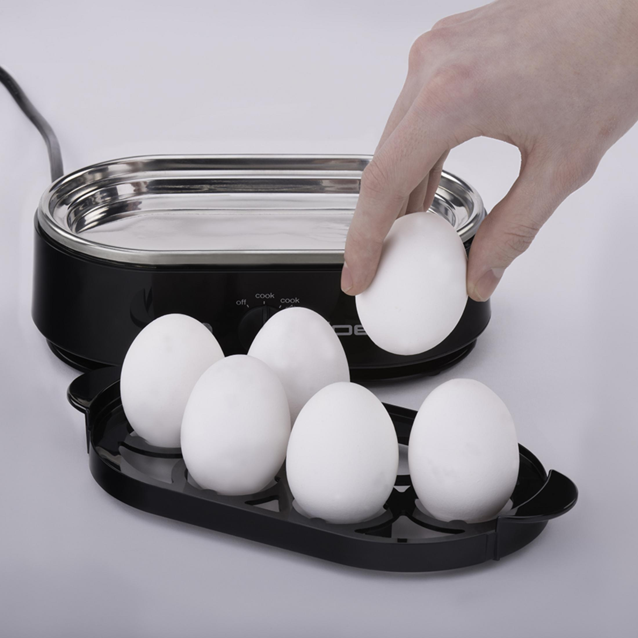 Gotowacz do jaj z sześcioma jajkami, jedno jest umieszczane przez rękę.