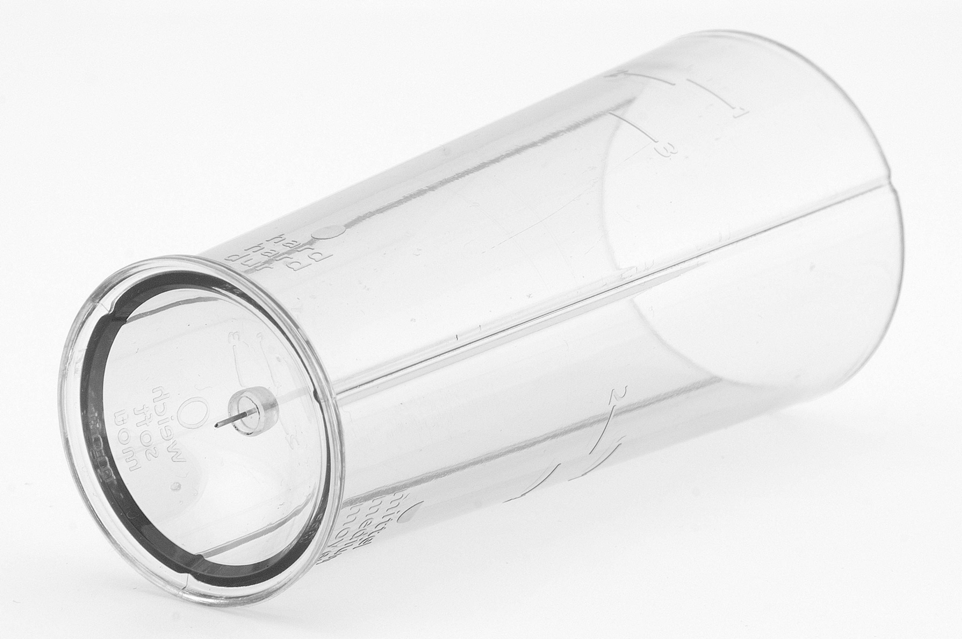 Przezroczysty plastikowy cylinder z oznaczeniami. Ułożony na białej powierzchni.