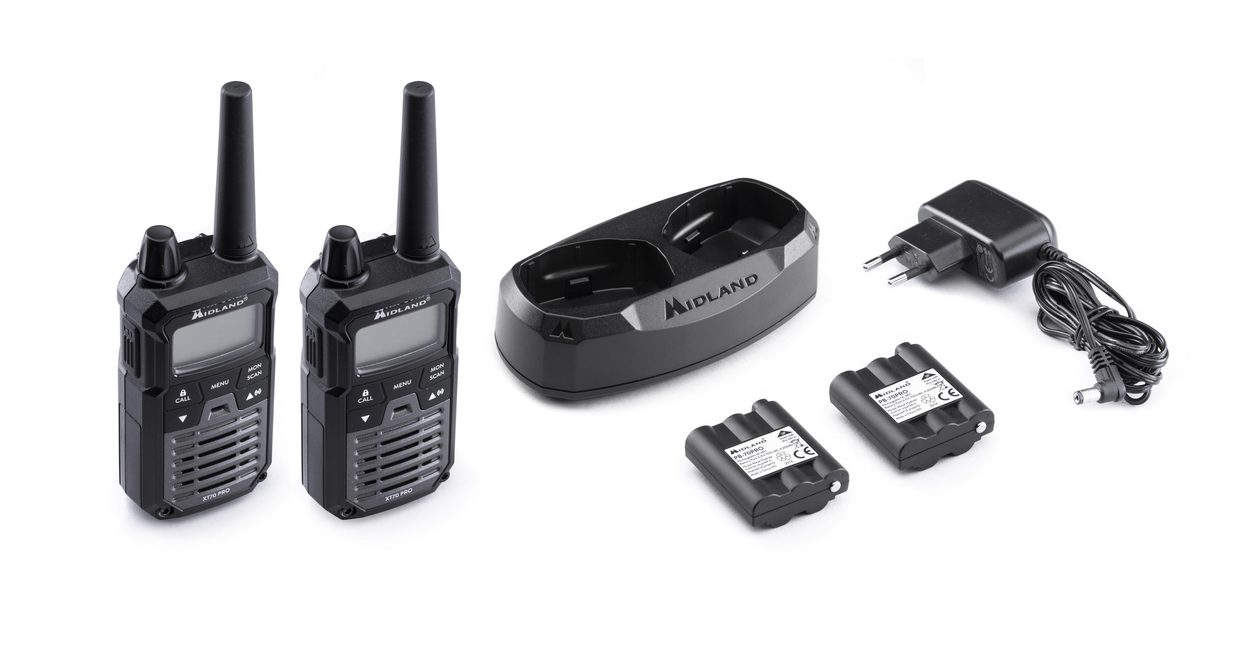 Dwa czarne krótkofalówki, stacja ładująca, dwa akumulatory i zasilacz na białym tle.
