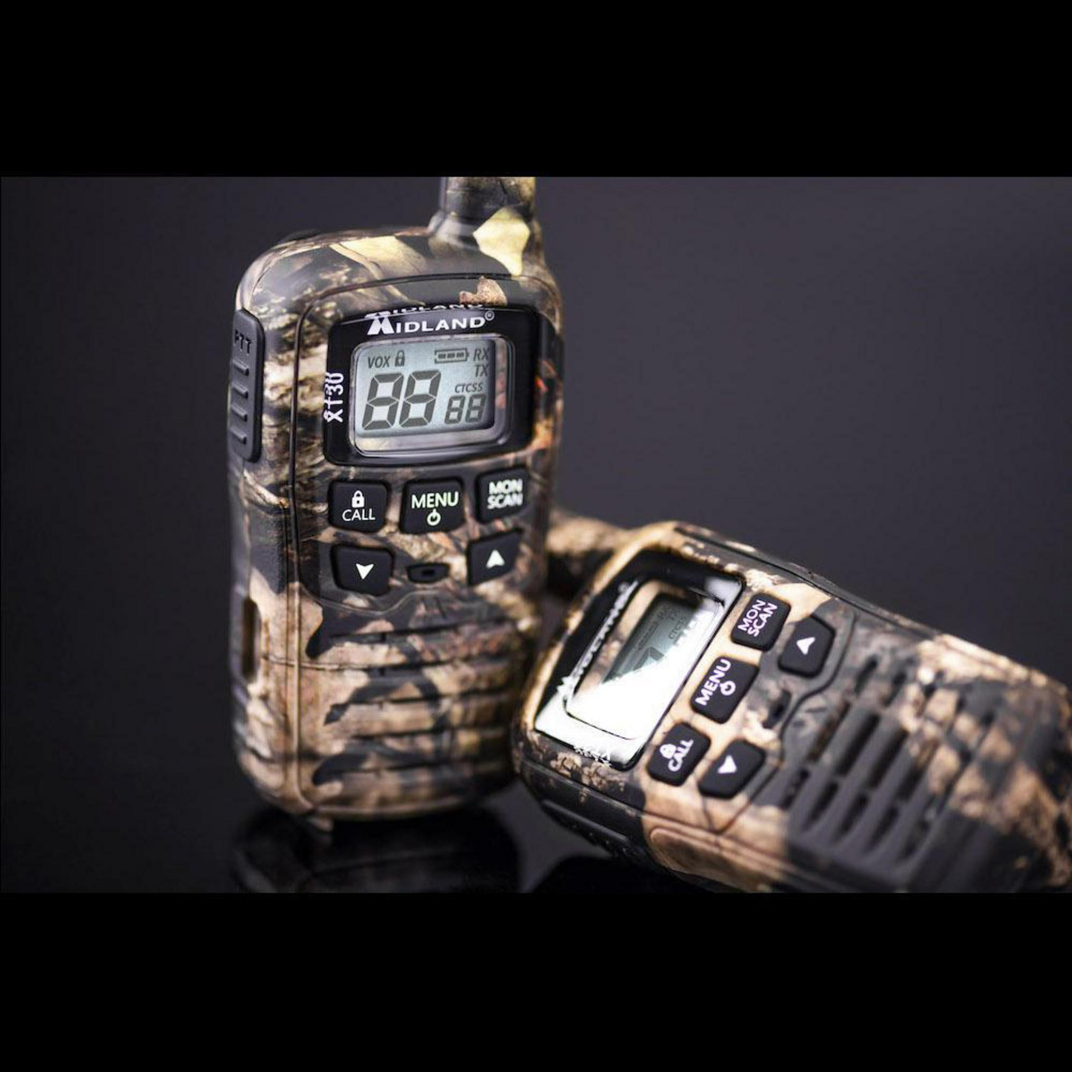 Zwei Tarn-Walkie-Talkies mit Digitalanzeigen, Knöpfen und Antennen, vor dunklem Hintergrund.