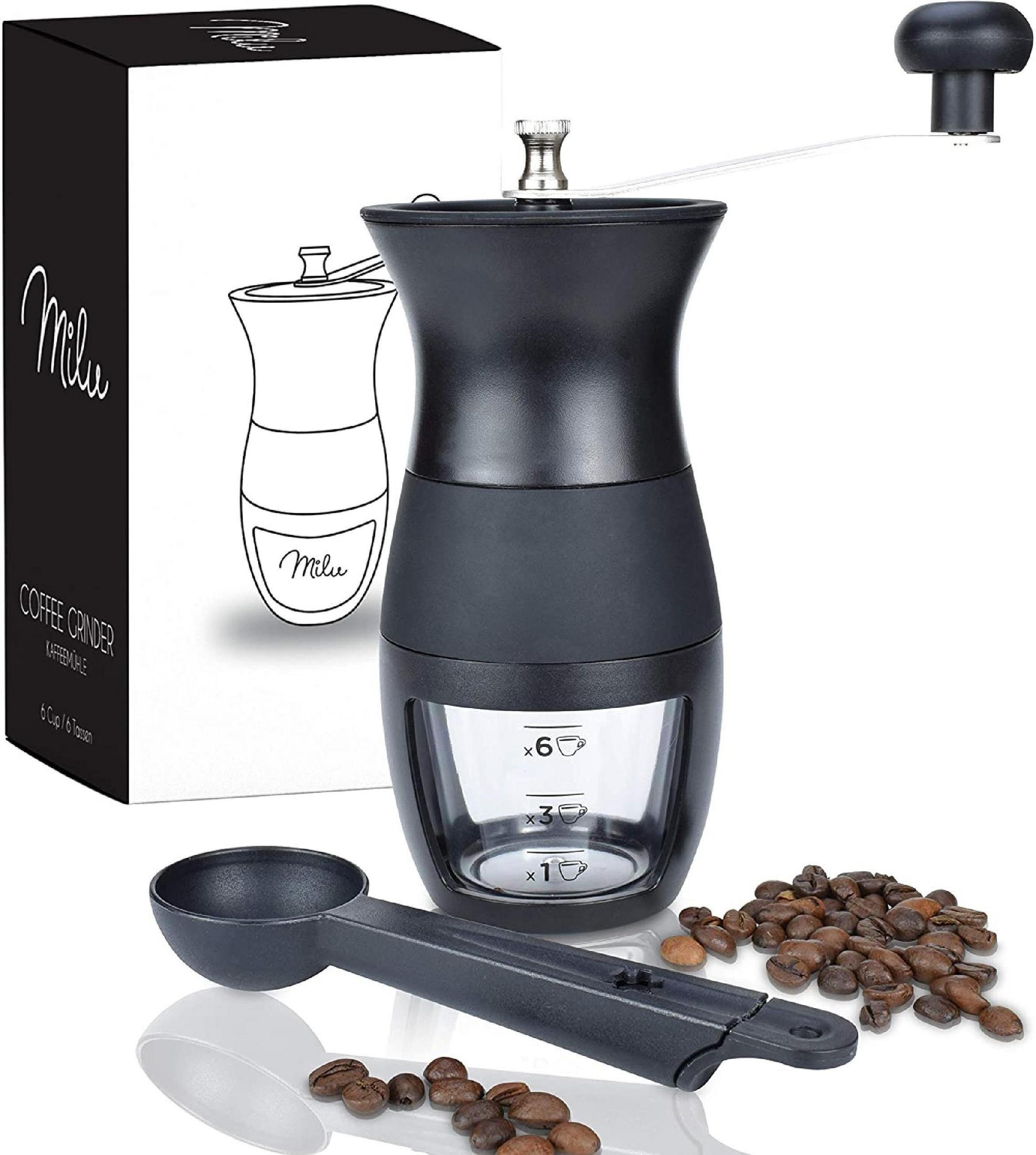 Schwarze Kaffeemühle, Messlöffel und Kaffeebohnen. Die Mühle hat eine Glasbasis mit Markierungen.