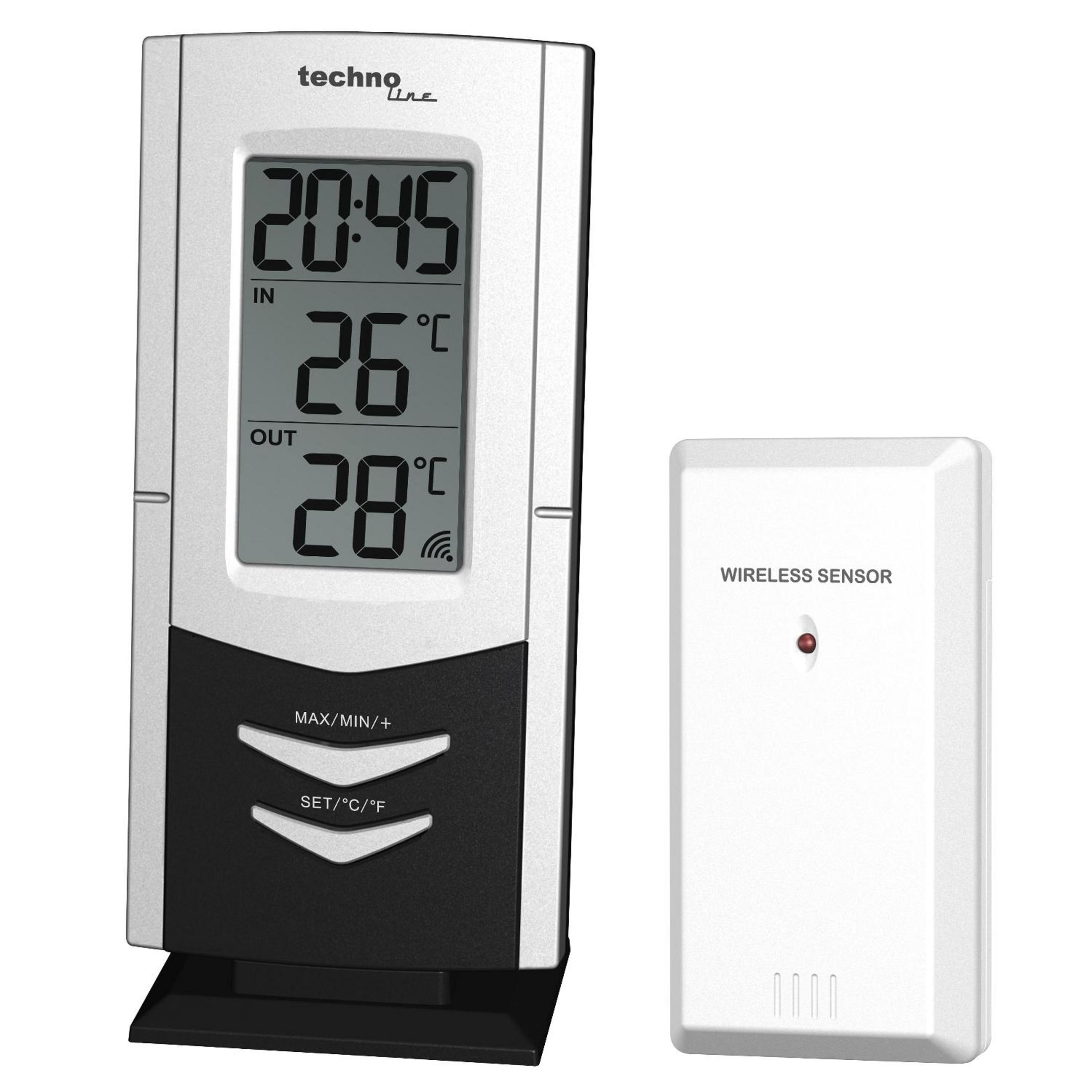 Cyfrowa stacja pogodowa wyświetla godzinę i temperaturę. Obok znajduje się czujnik bezprzewodowy. Ma czerwone światło.