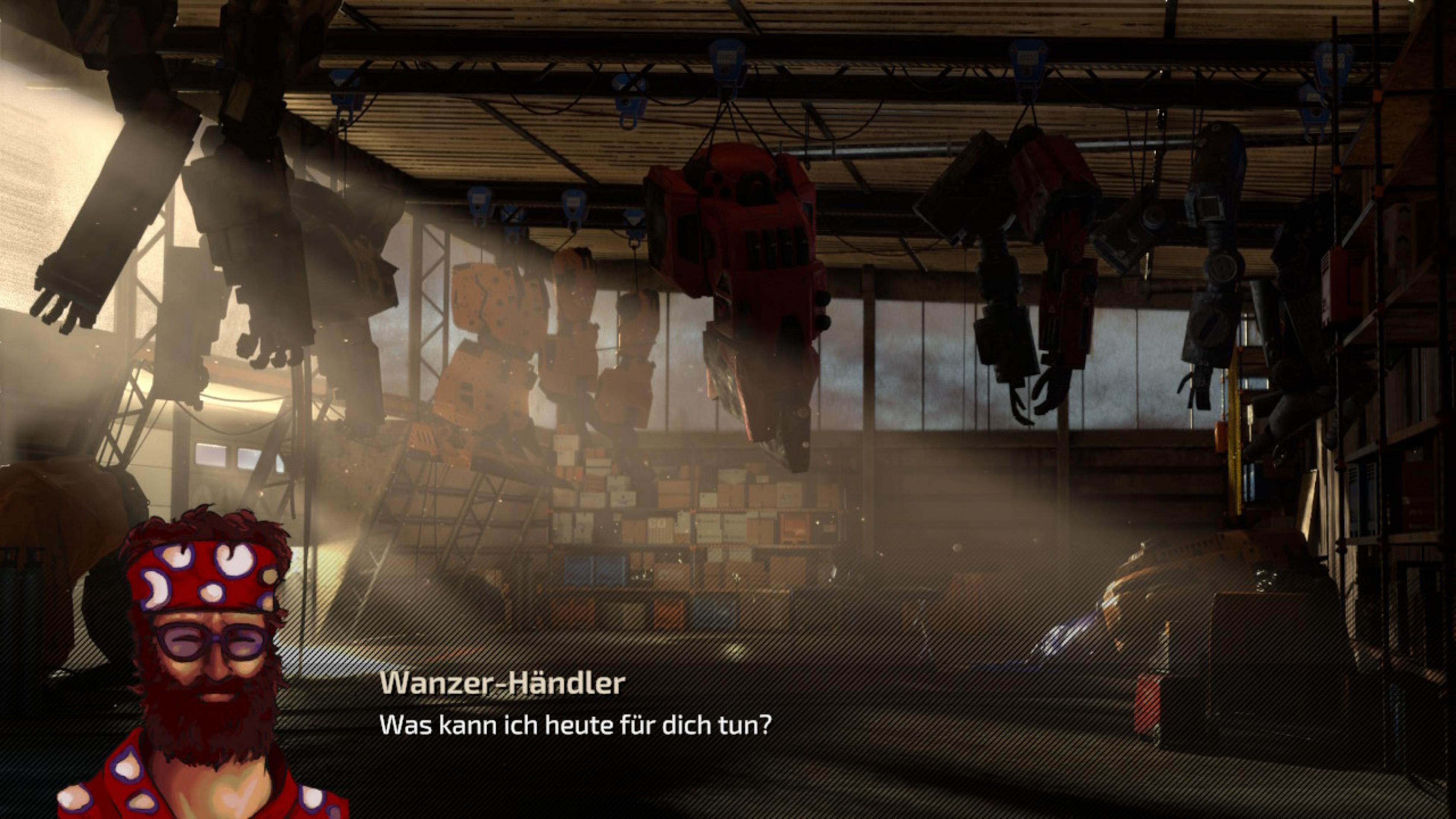 Ein Mann mit Brille und Bart spricht in einer Werkstattumgebung mit dem Betrachter.
