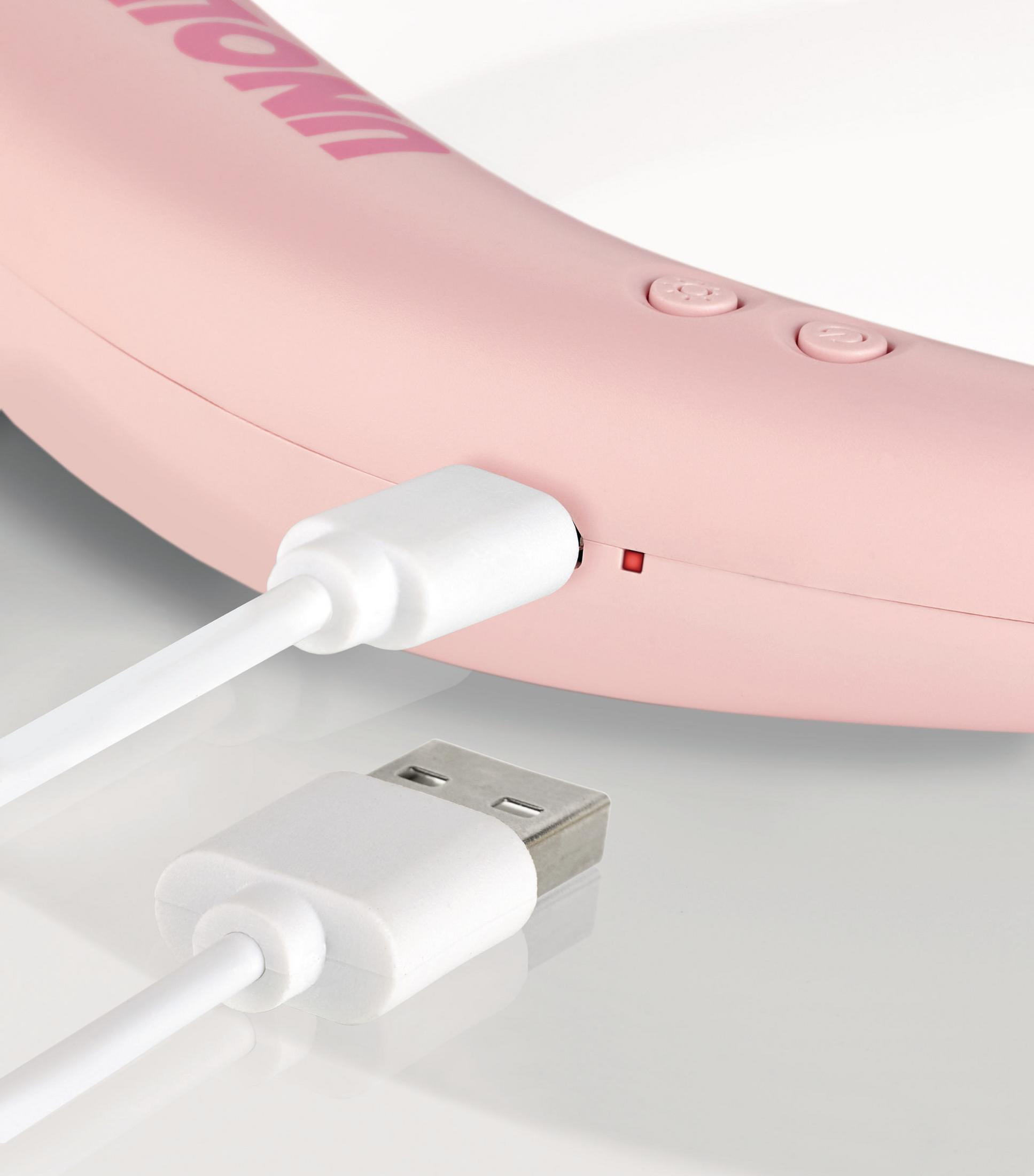 Różowy kabel ładujący podłączony do różowego urządzenia. Pokazany jest biały kabel USB.