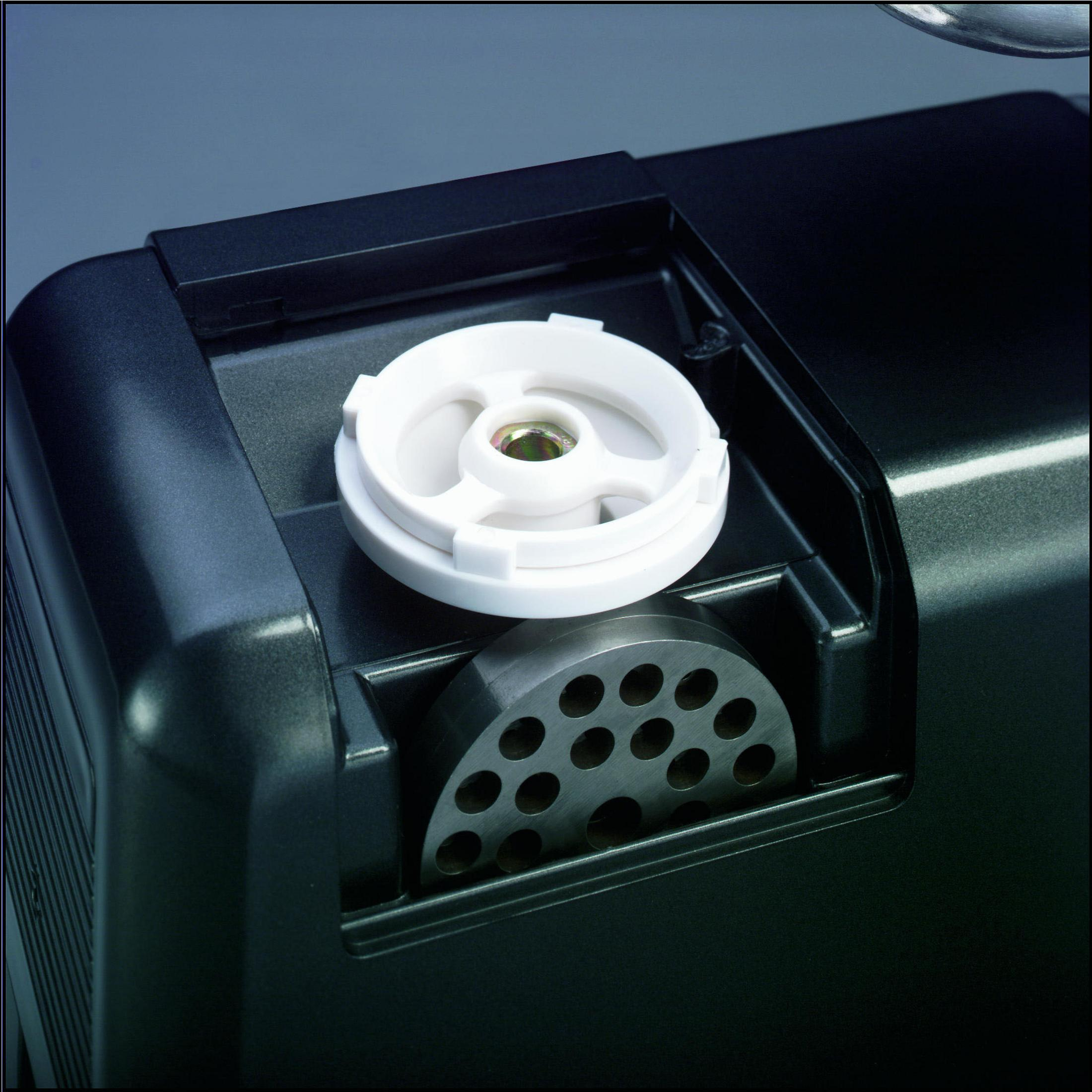 Zbliżenie rozebranej maszynki do mięsa, z płytą i białą częścią.