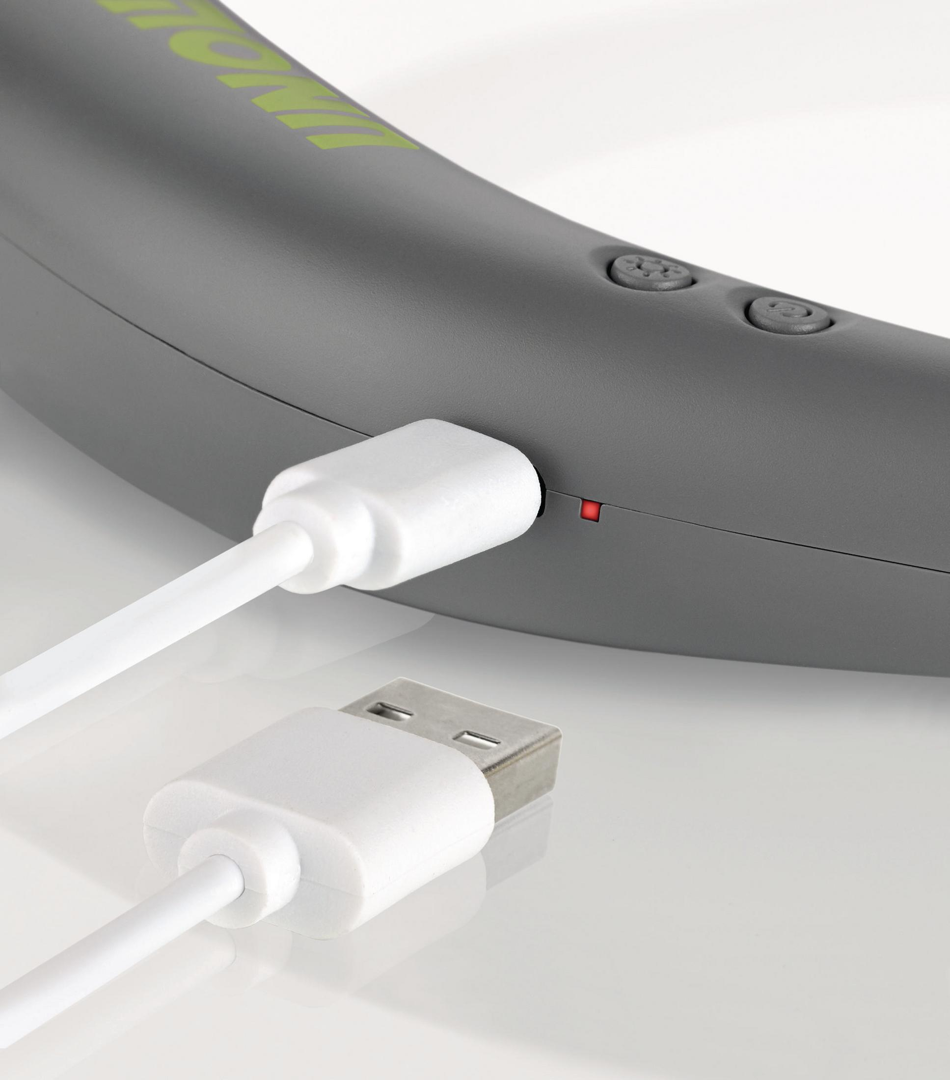 Nahaufnahme eines grauen Nackenmassagegeräts mit eingestecktem weißen USB-Kabel, lädt.