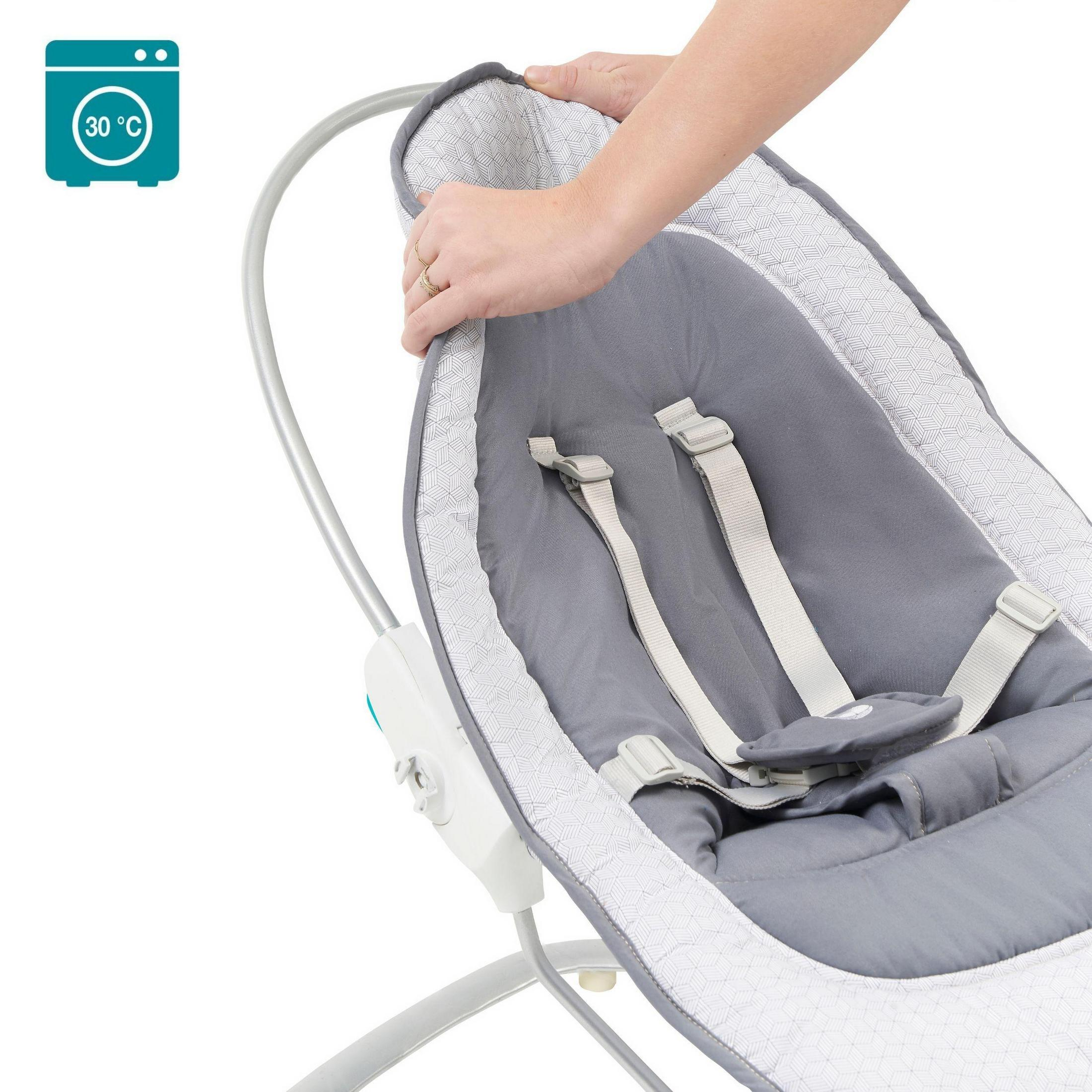 Eine Babywippe mit grauem Stoff, eine Hand, die den Sitz verstellt, und ein Waschmaschinensymbol.