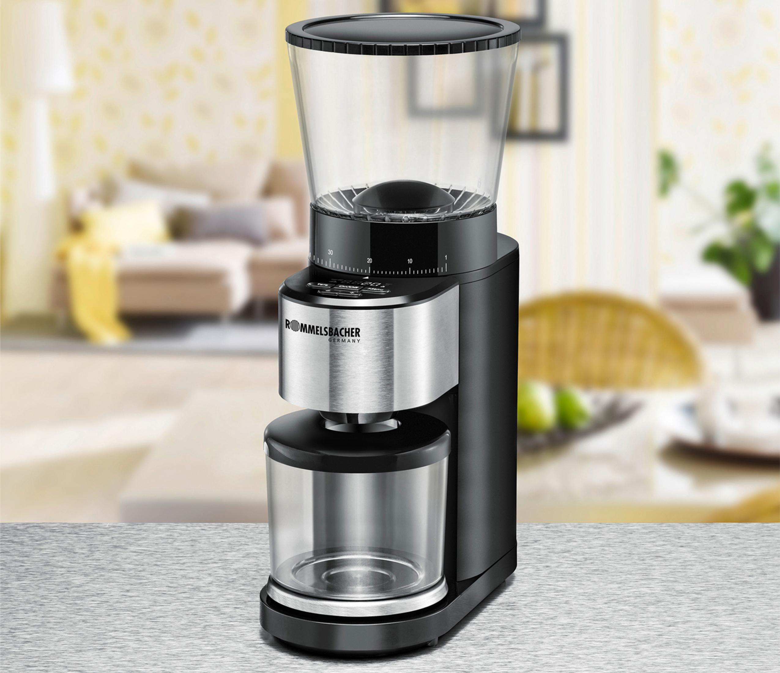 Czarny i srebrny młynek do kawy z przezroczystym pojemnikiem na ziarna. Posiada wyświetlacz cyfrowy.