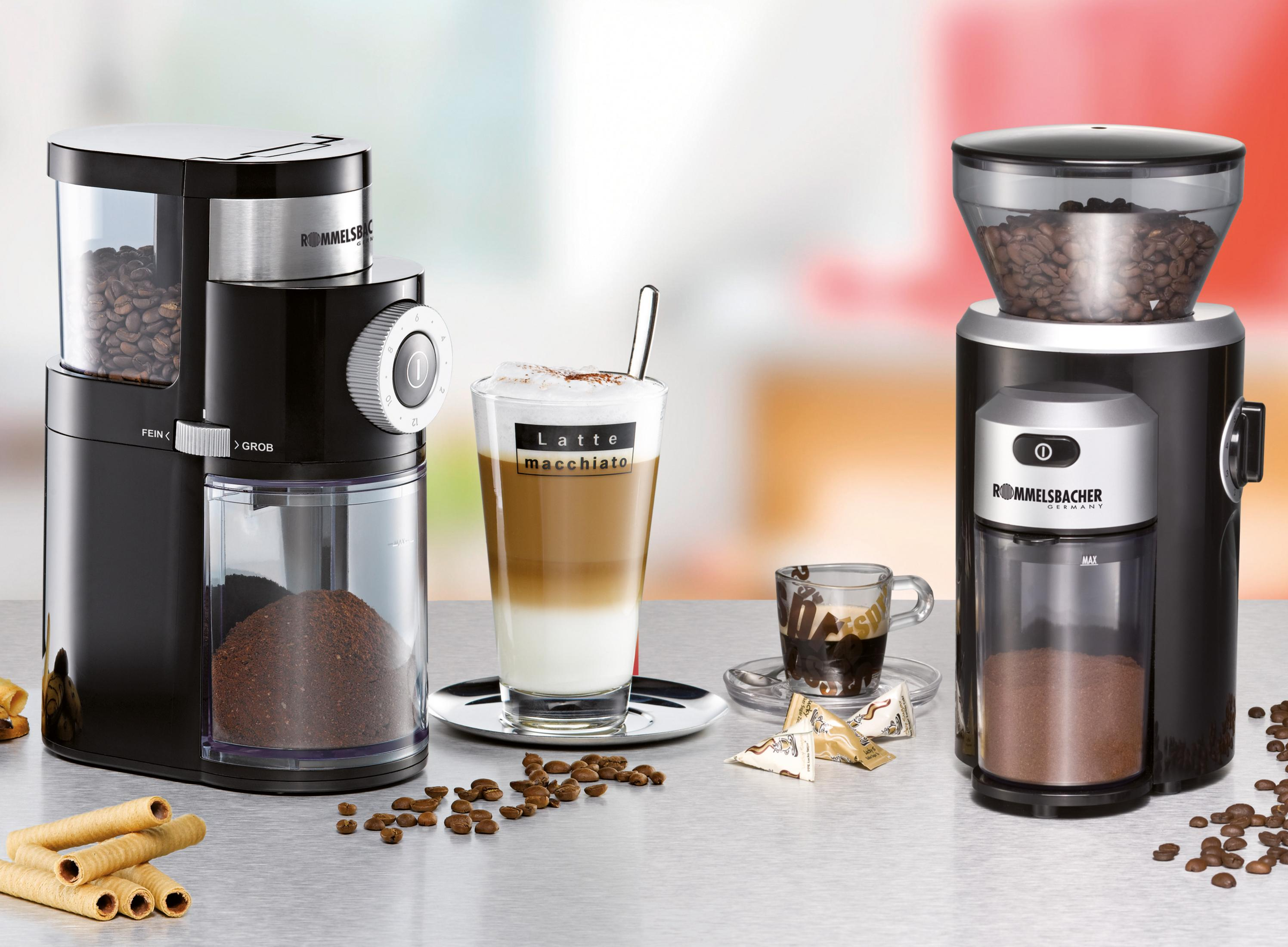 Młynki do kawy, kawa i latte macchiato na stole.