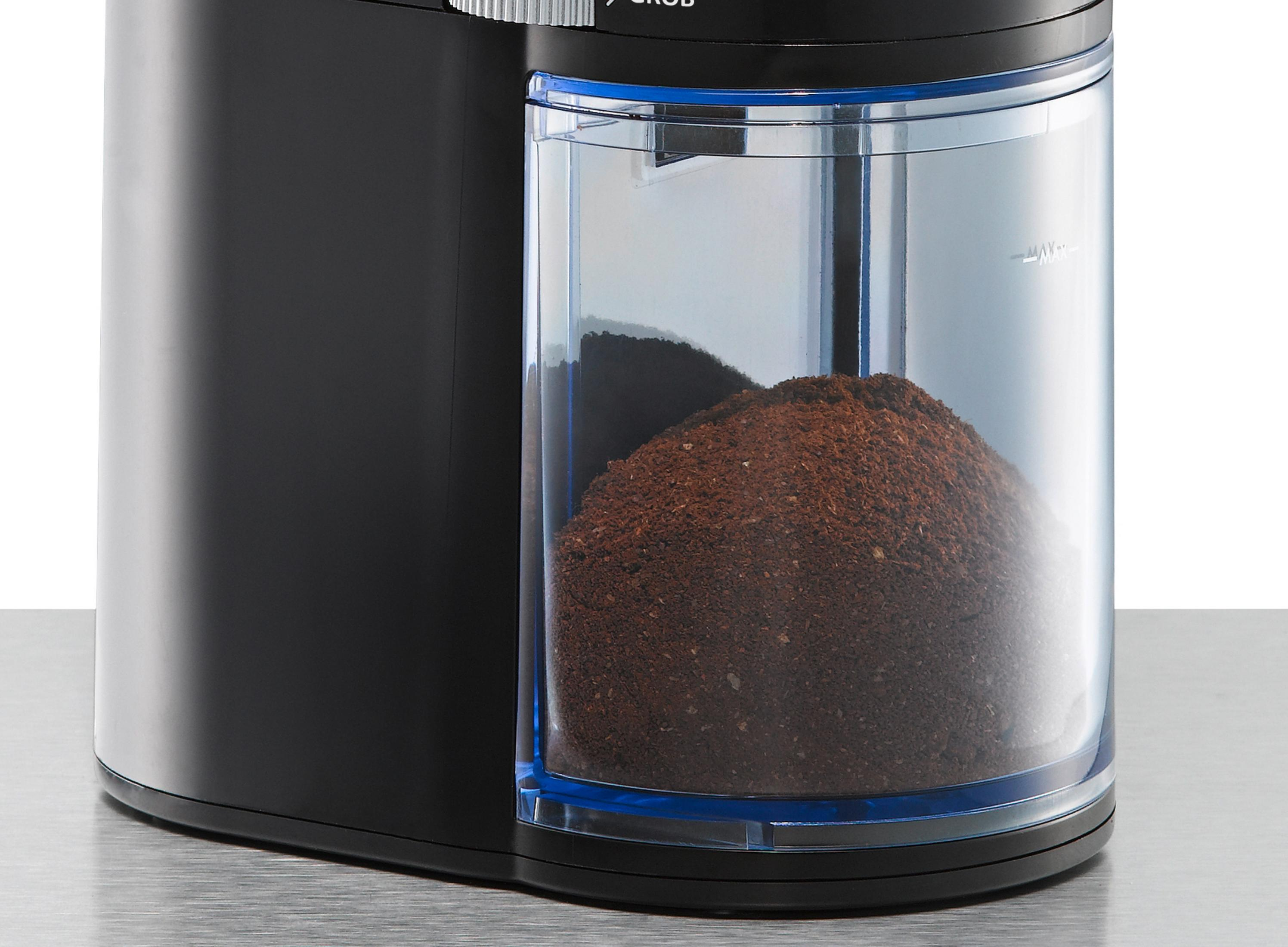 Młynek do kawy. Czarny z przezroczystym pojemnikiem wypełnionym zmieloną kawą. Białe tło.