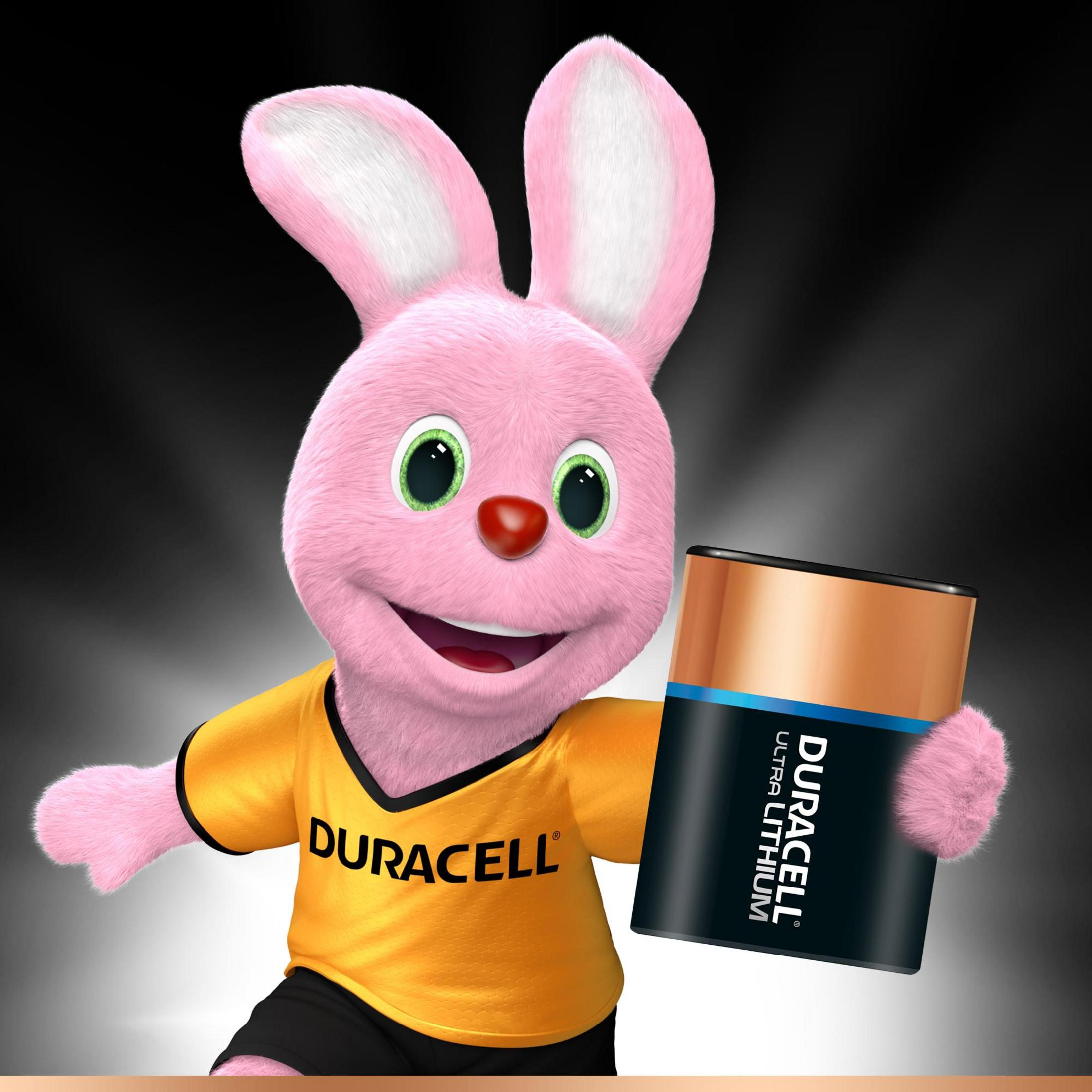 Lapin rose Duracell tenant une pile Duracell Ultra Lithium, portant un t-shirt jaune Duracell.