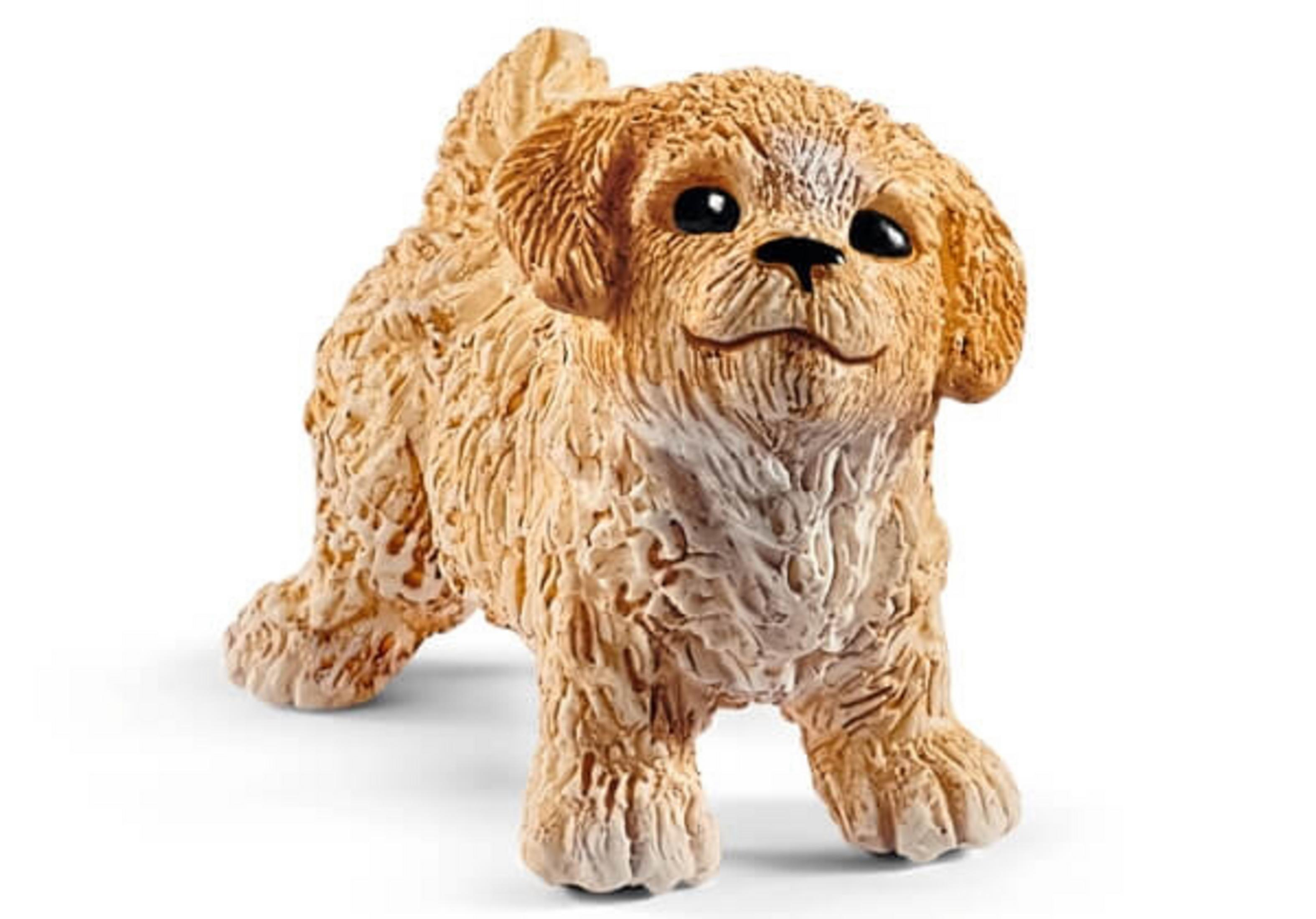 Eine kleine, hellbraune Welpenfigur steht mit fröhlichem Gesichtsausdruck. Es hat ein strukturiertes Fell.