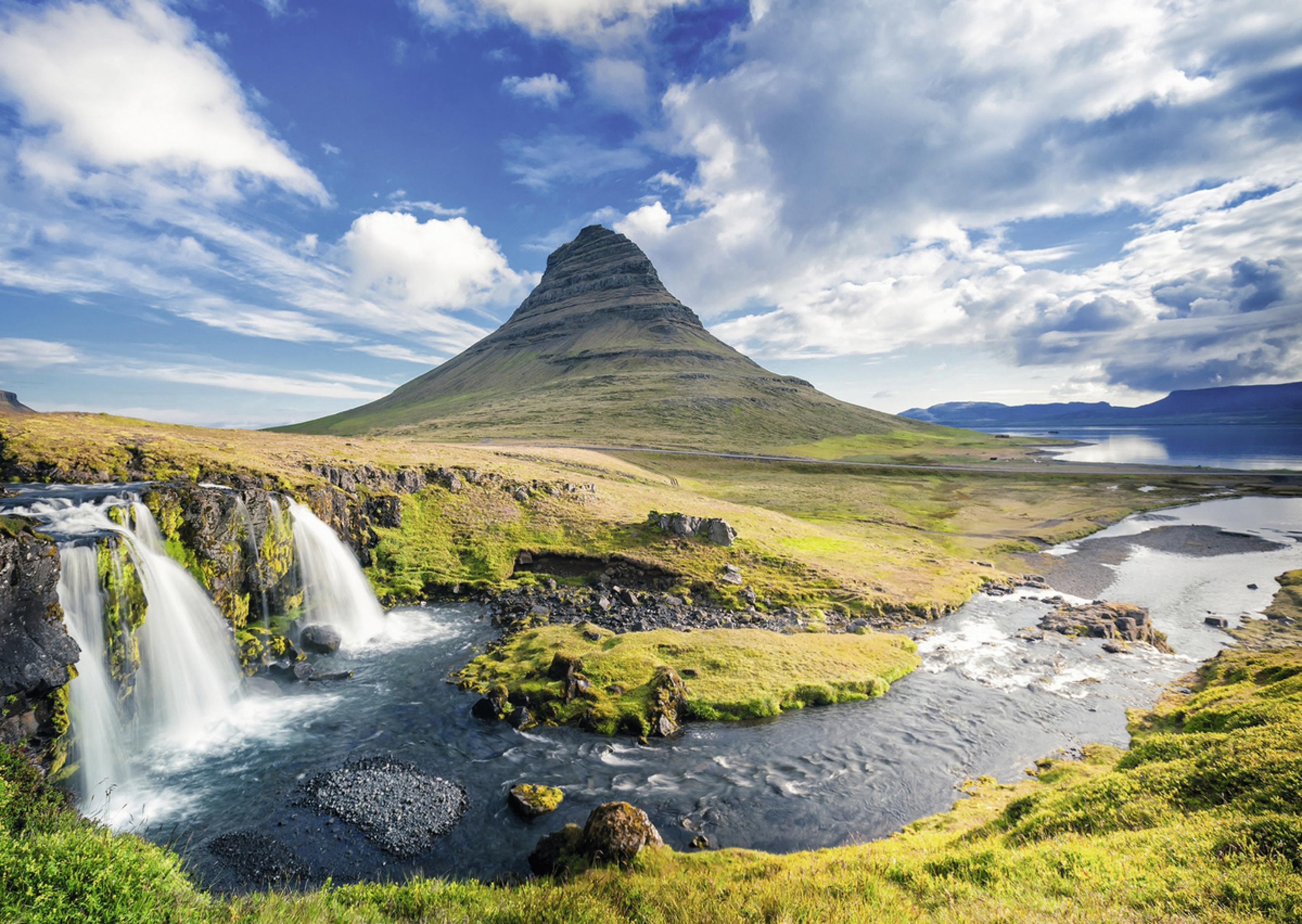 Landschaft: Berg, Wasserfälle, Fluss, grüne Felder, blauer Himmel mit Wolken. Eine wunderschöne Landschaft.
