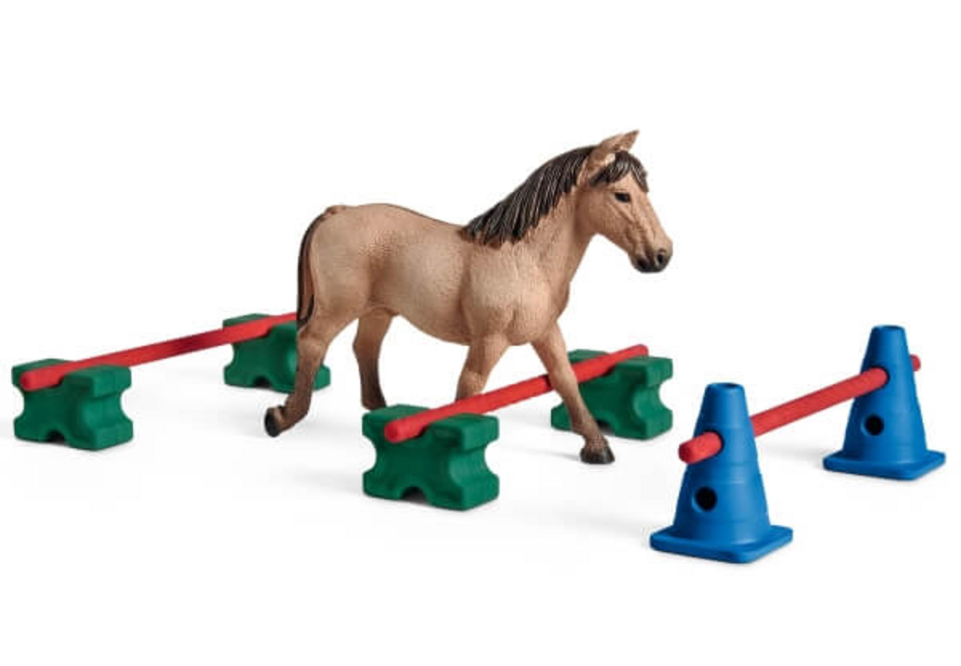 Zabawkowy koń przechodzący przez tor z czerwonymi drążkami i niebieskimi pachołkami.