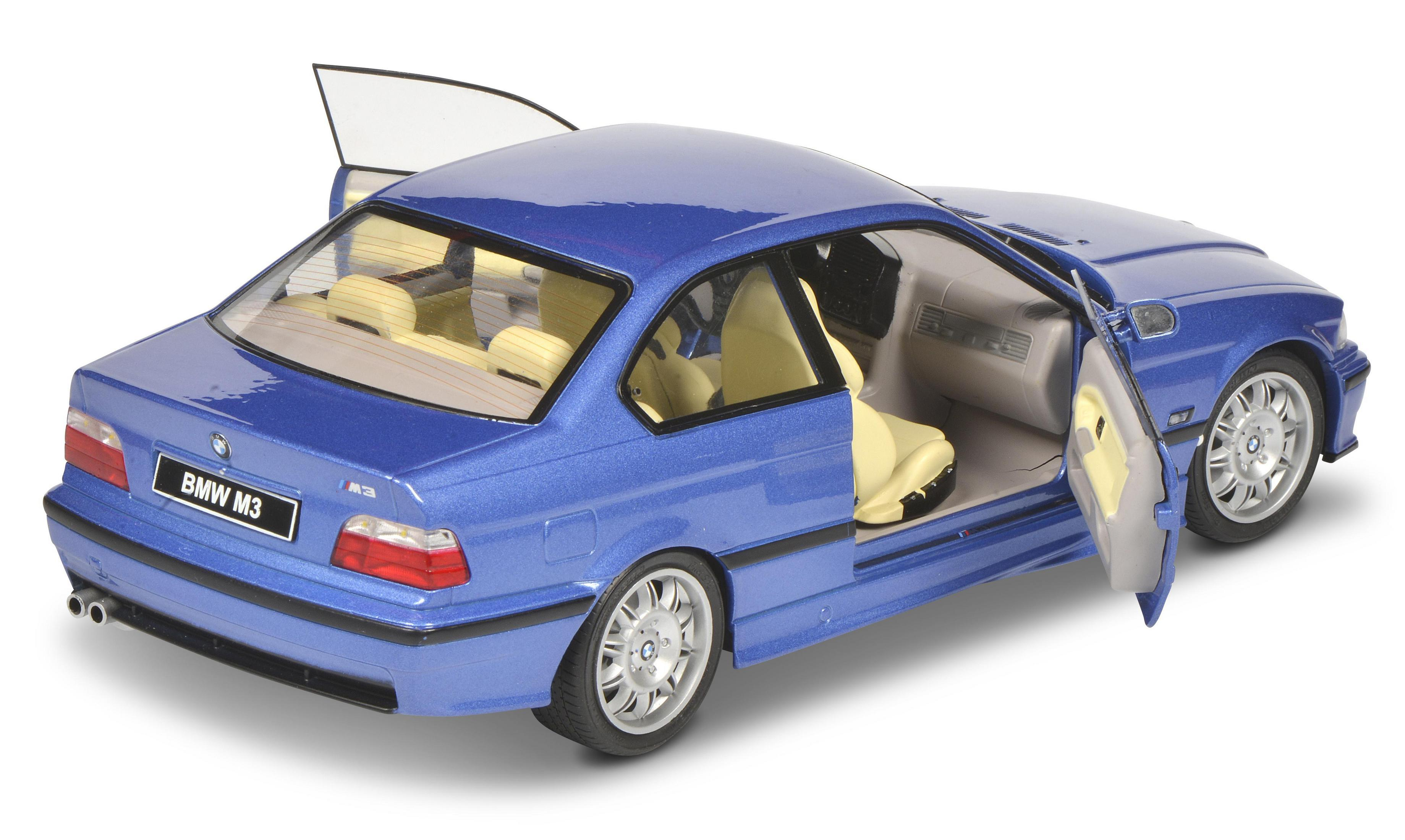Modello di auto blu BMW M3 con porte aperte, sfondo bianco. Dettagli interni visibili.