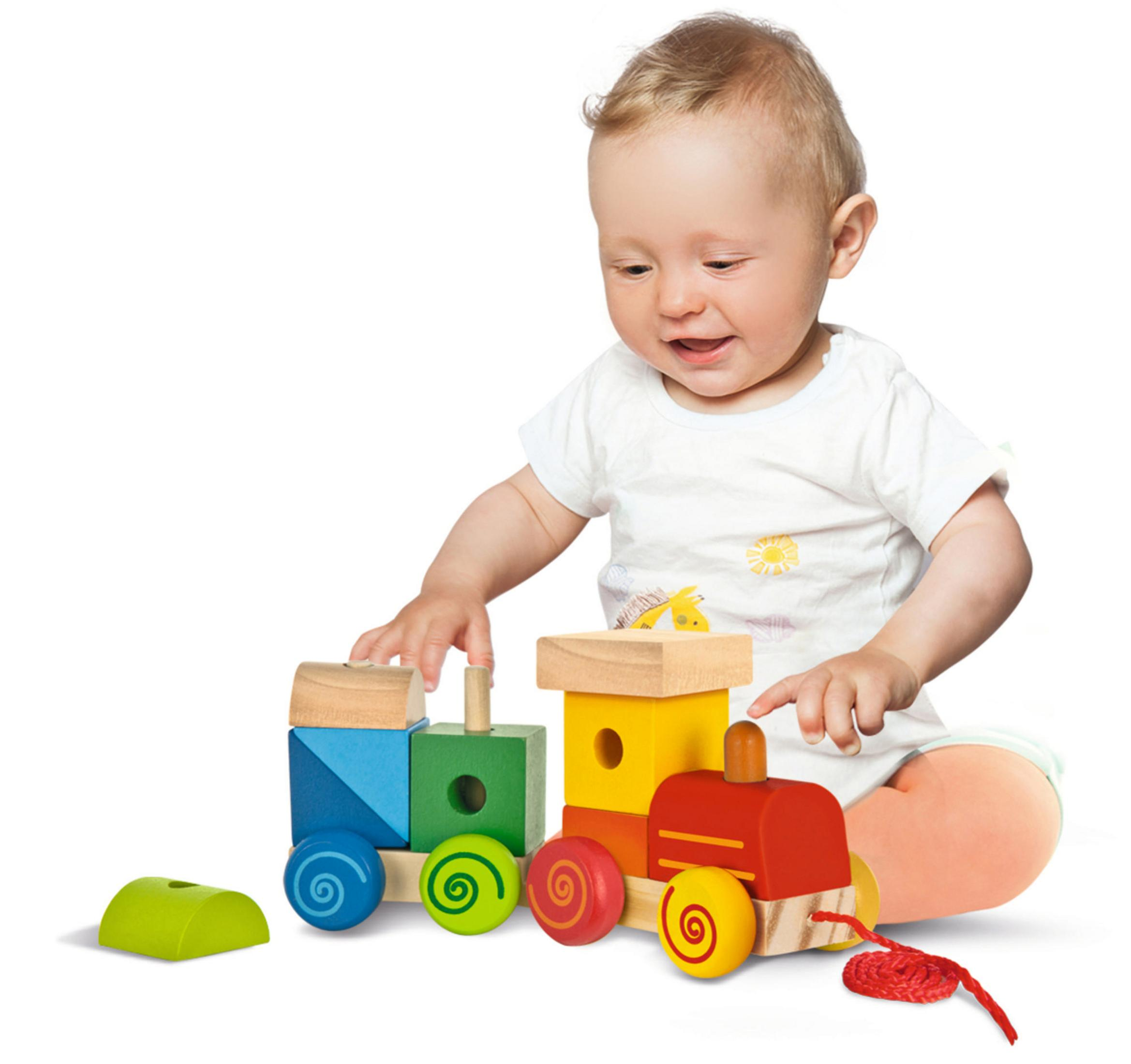 Baby spielt mit einem bunten Holzzug. Er hat blaue, grüne, gelbe und rote Blöcke.