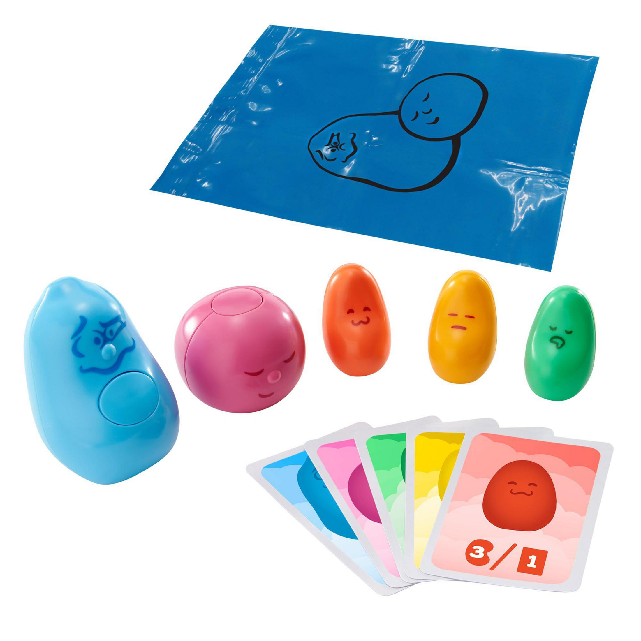 Ein Spielset mit bunten, abstrakten Formen. Ein blaues Blatt mit einer Zeichnung befindet sich oben.