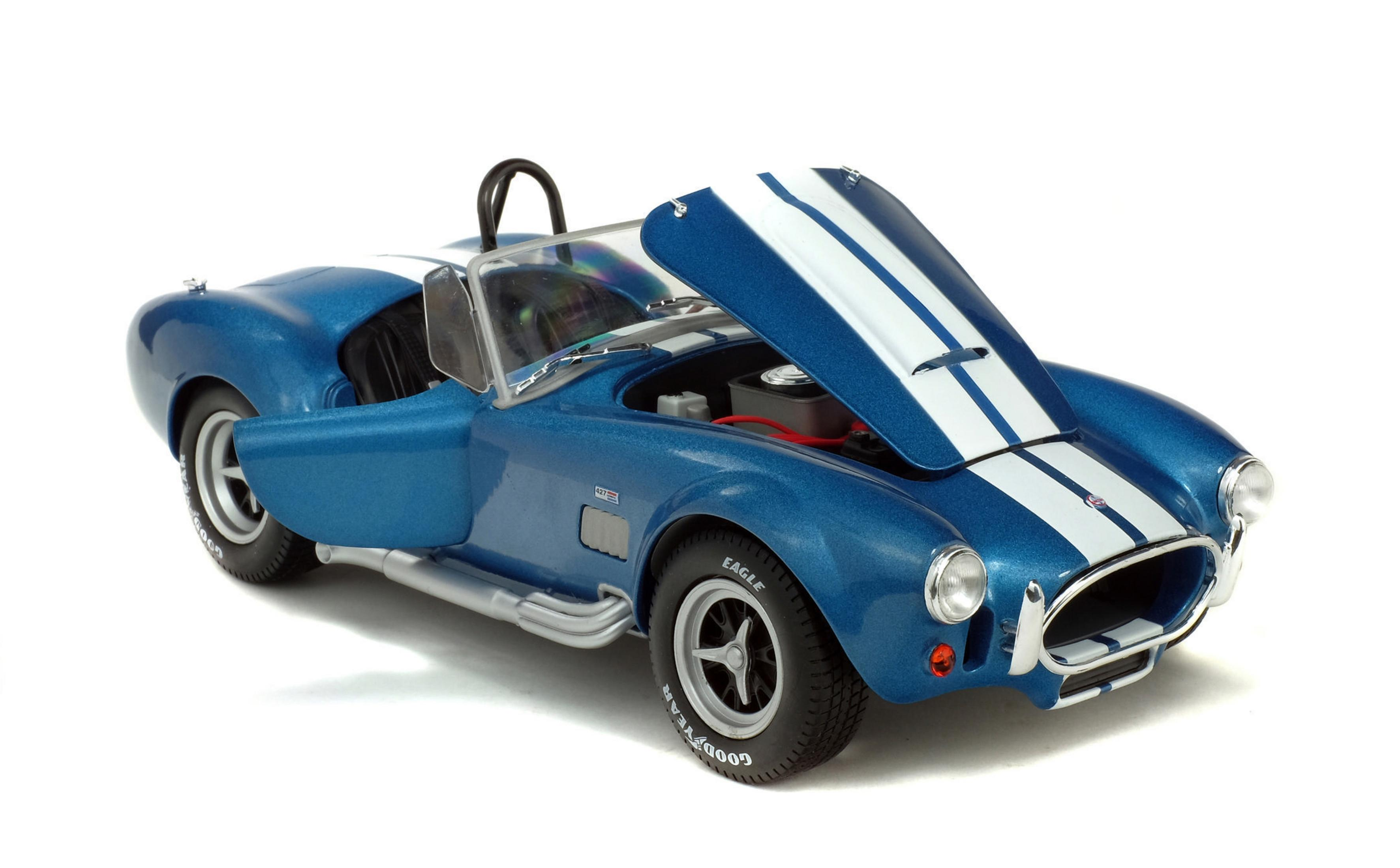 Macchina giocattolo blu con cofano aperto, strisce bianche, pneumatici neri.