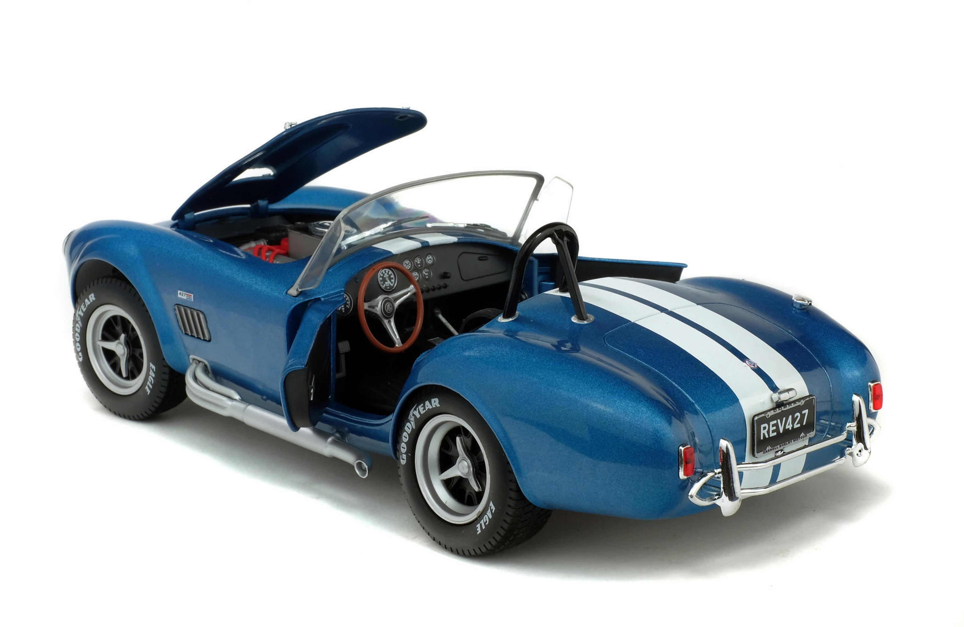 Macchina giocattolo blu con porta aperta, strisce bianche, pneumatici neri.