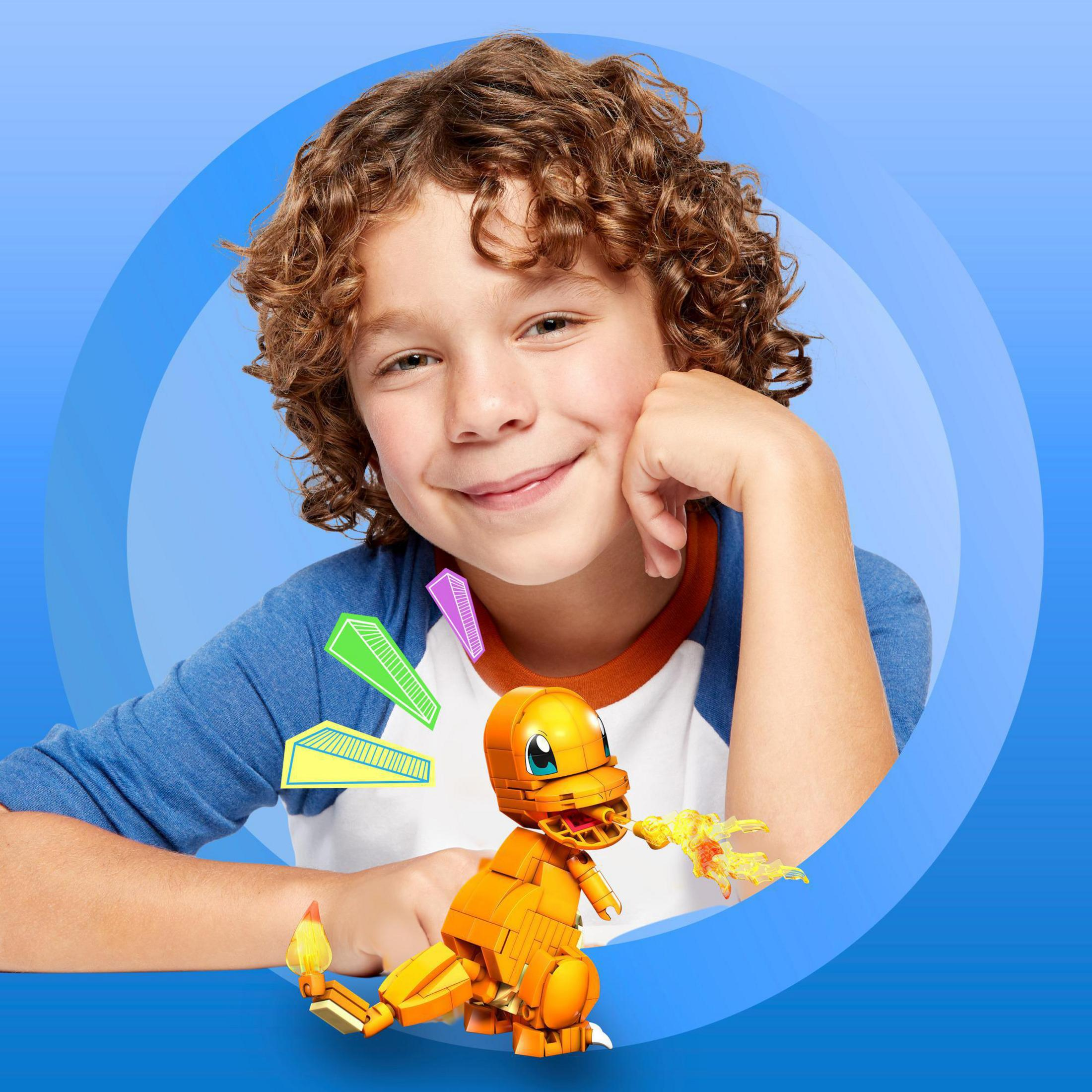 Ein Junge mit einem LEGO Charmander-Modell, hält ein paar LEGO-Steine, in einem blau getönten Hintergrund.