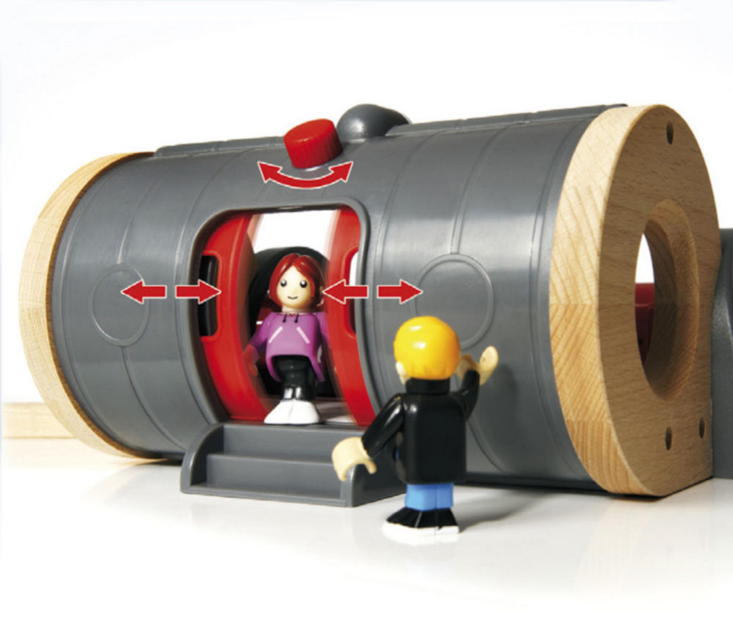 Scena zabawki stacji kolejowej, z figurkami i czerwonymi drzwiami.