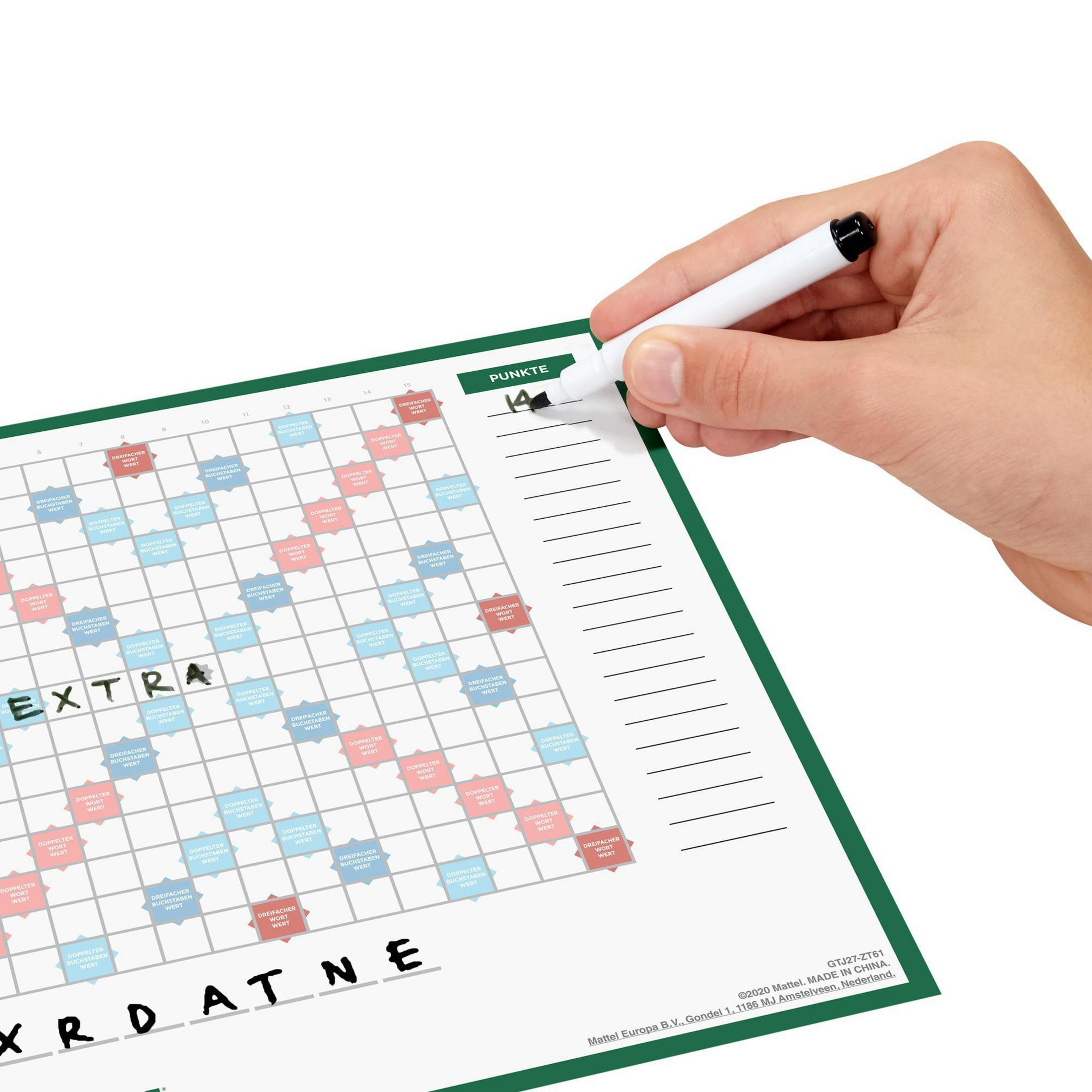 Ręka pisze na arkuszu wyników Scrabble, zielona ramka.