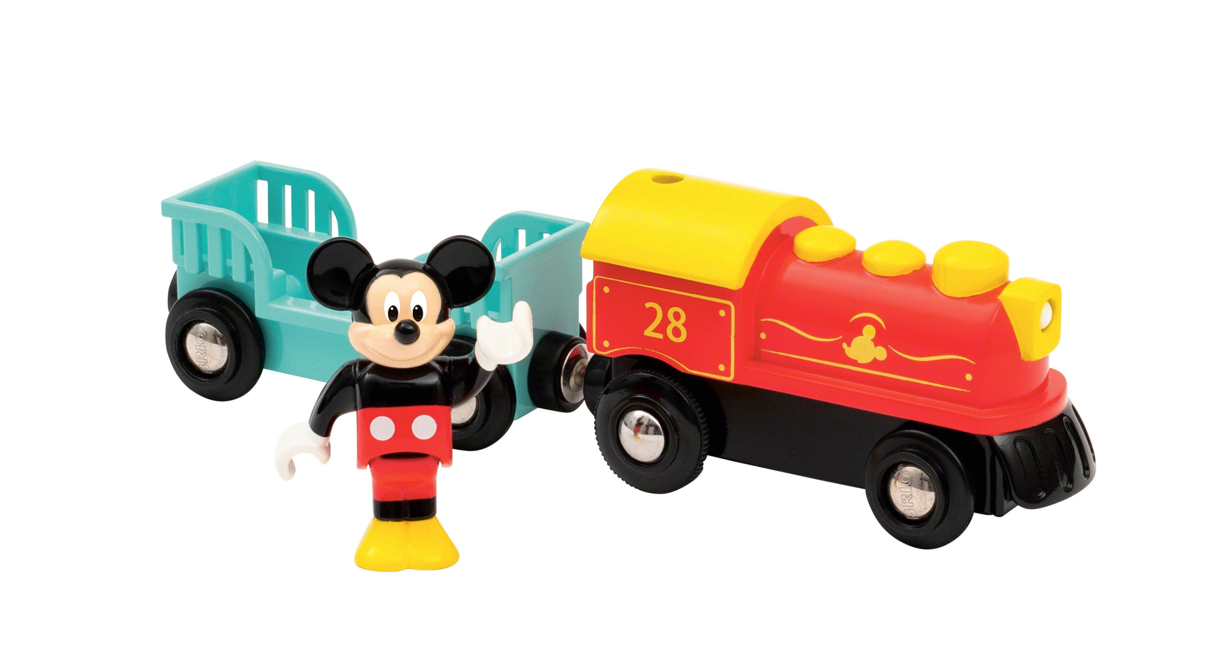 Myszka Miki z zabawkami kolejowymi. Miki stoi obok czerwonego pociągu i niebieskiego wagonu.