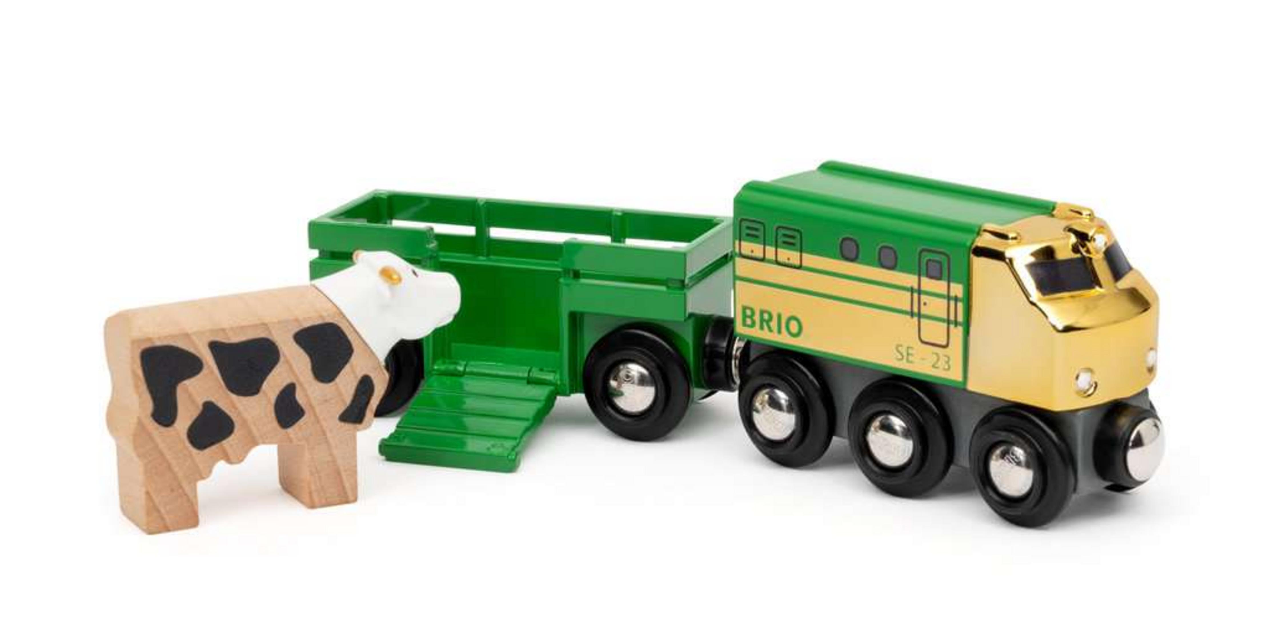 Drewniany pociąg-zabawka i wagon bydlęcy z figurką krowy. Kolory zielony, złoty i brązowy.