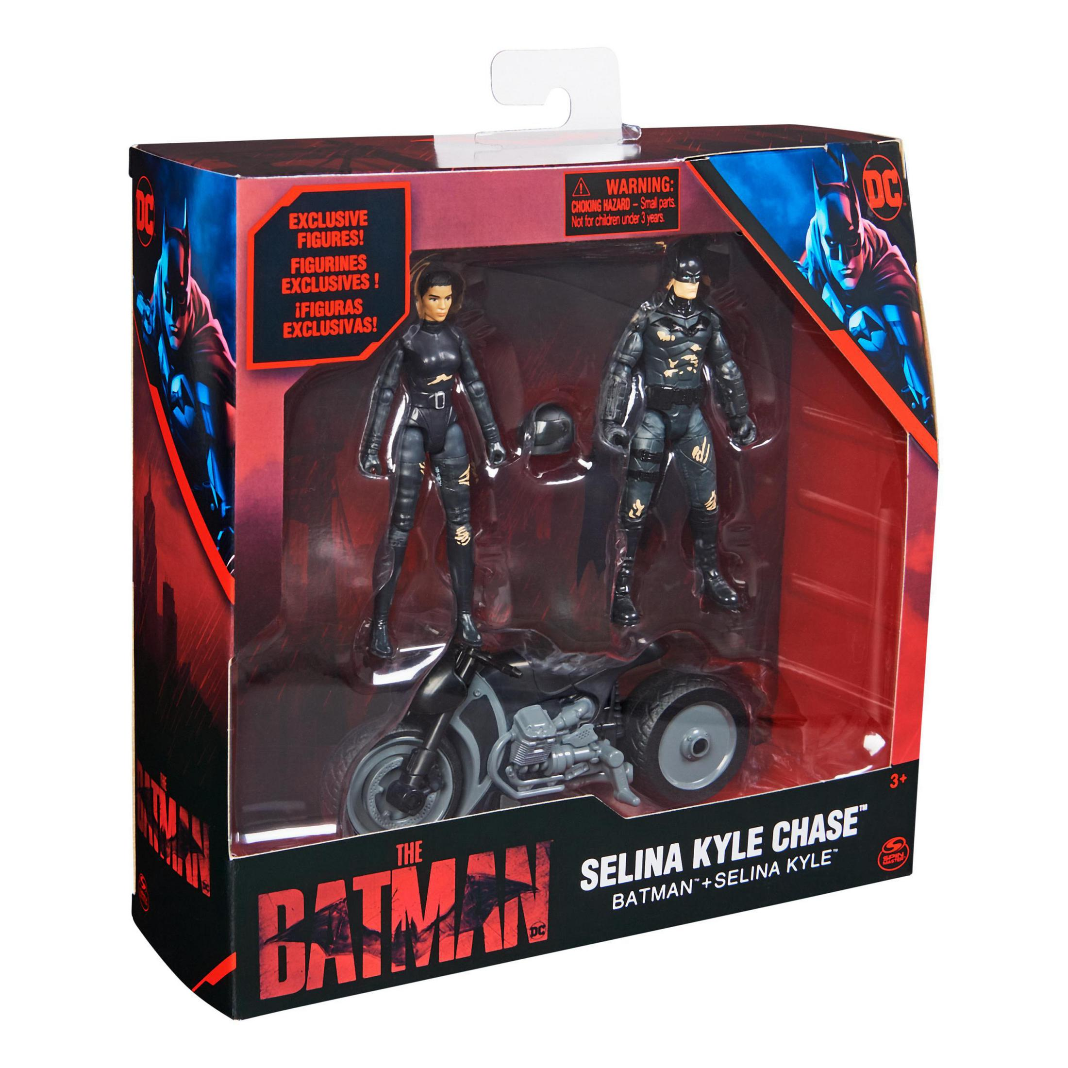 Ein Spielzeugset mit Batman, Selina Kyle und einem Motorrad in einer Box. Schwarz-rotes Farbschema.