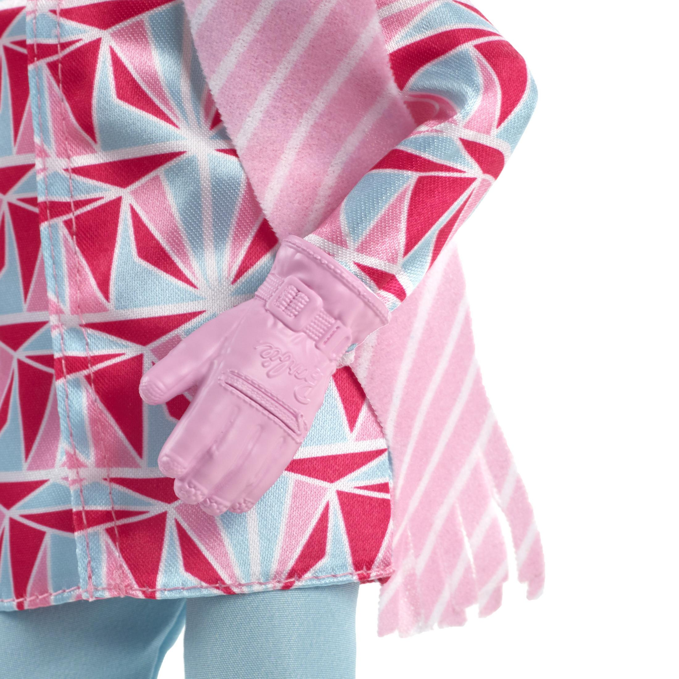 Zbliżenie różowej rękawicy Barbie i wzorzystego płaszcza z niebieskimi i czerwonymi trójkątami.