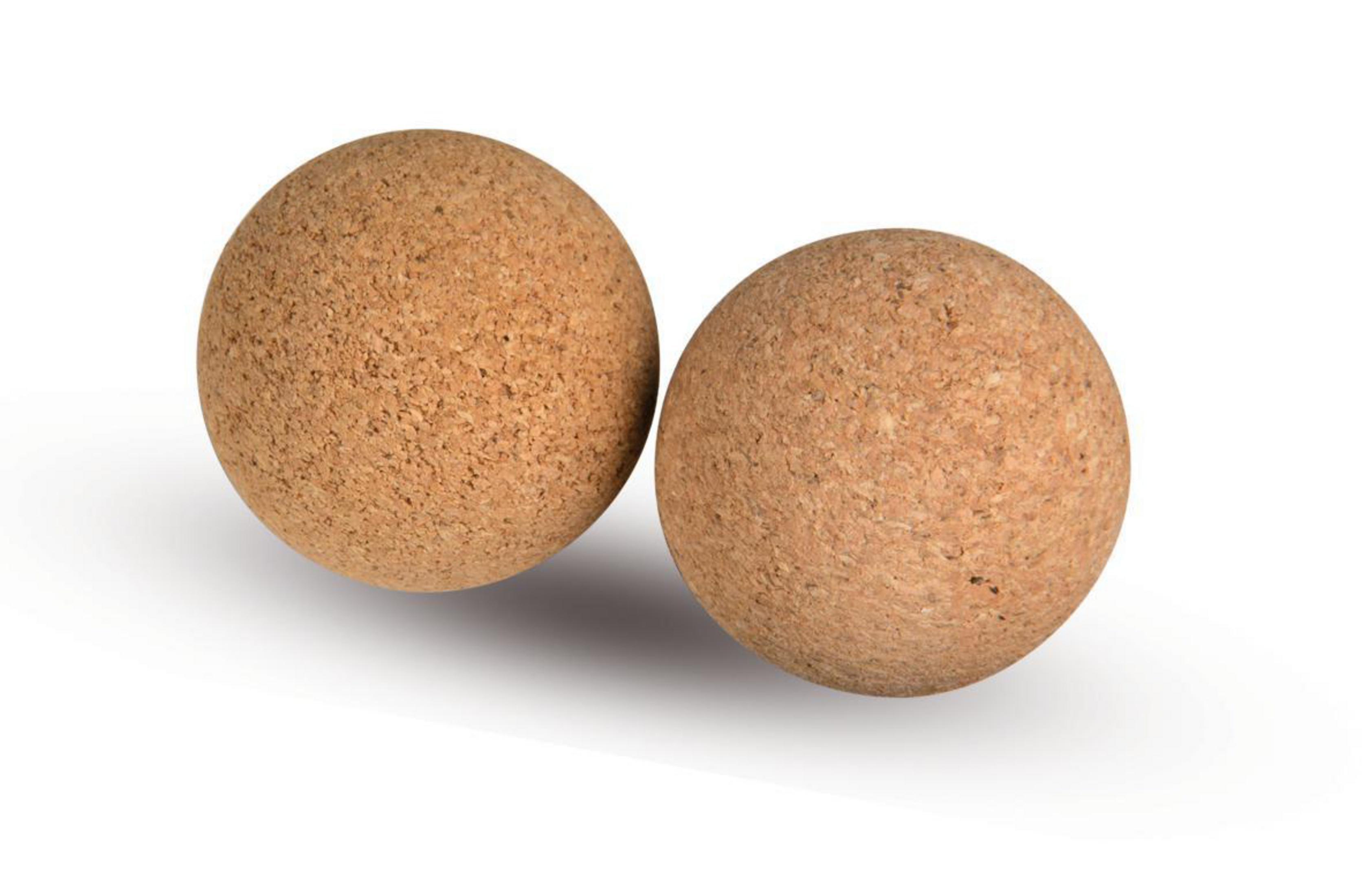 Dwie brązowe kulki korkowe, spoczywające na białym tle. Kulki są gładkie.