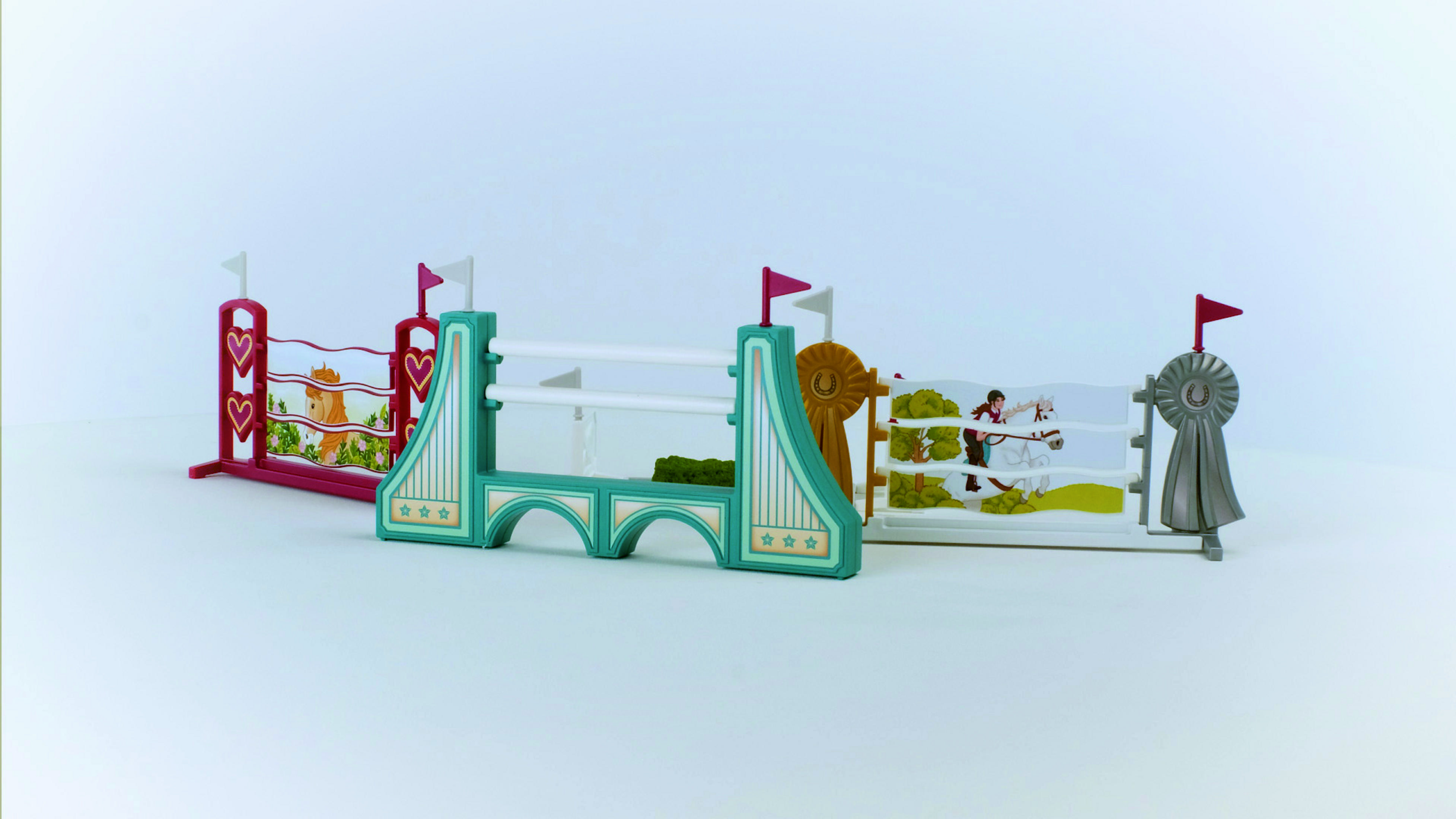 Ein Spielzeug-Pferdesprung-Set. Bunte Zäune. Weißer Hintergrund.