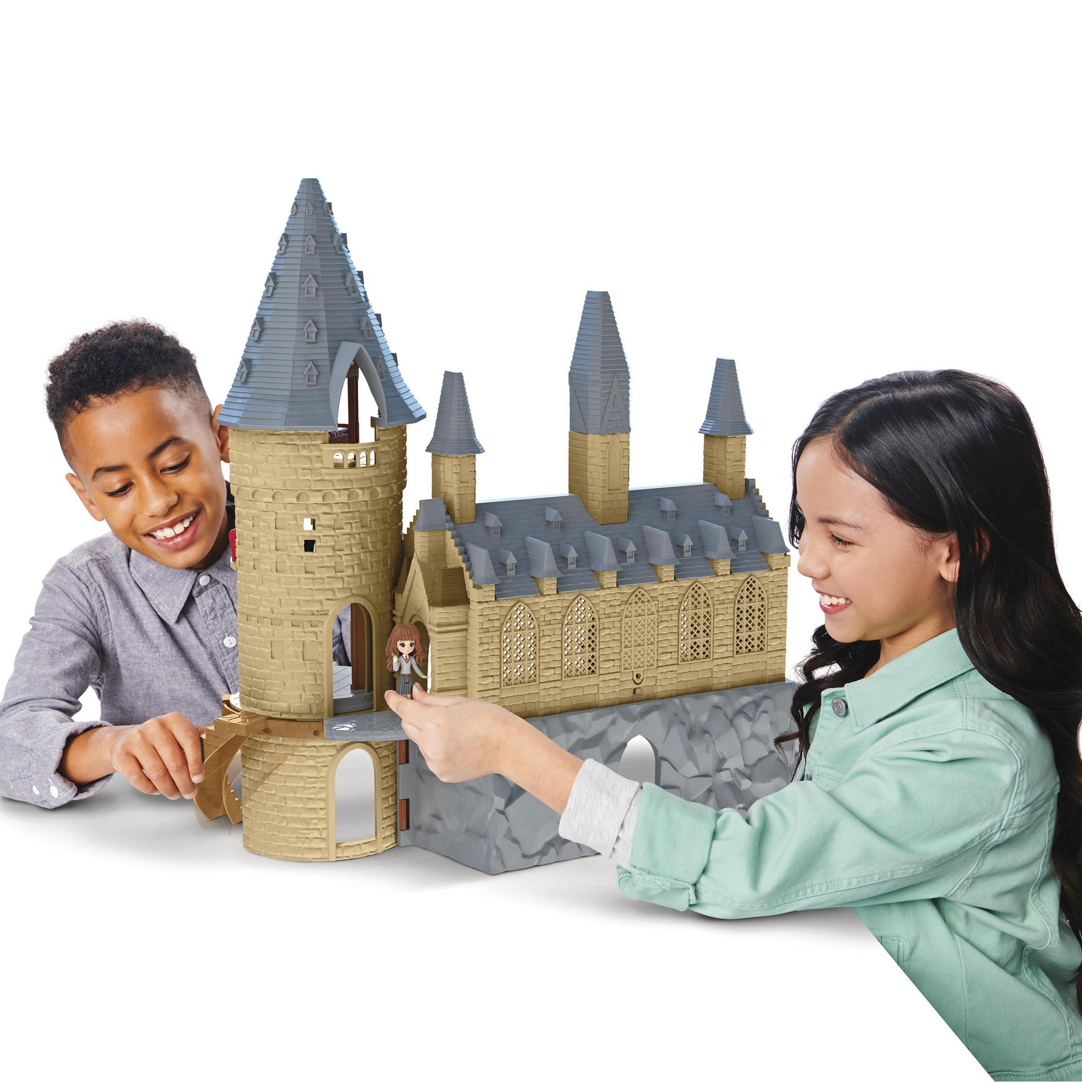 Dwoje dzieci bawiących się zamkiem zabawek. Widoczna wieża i most.