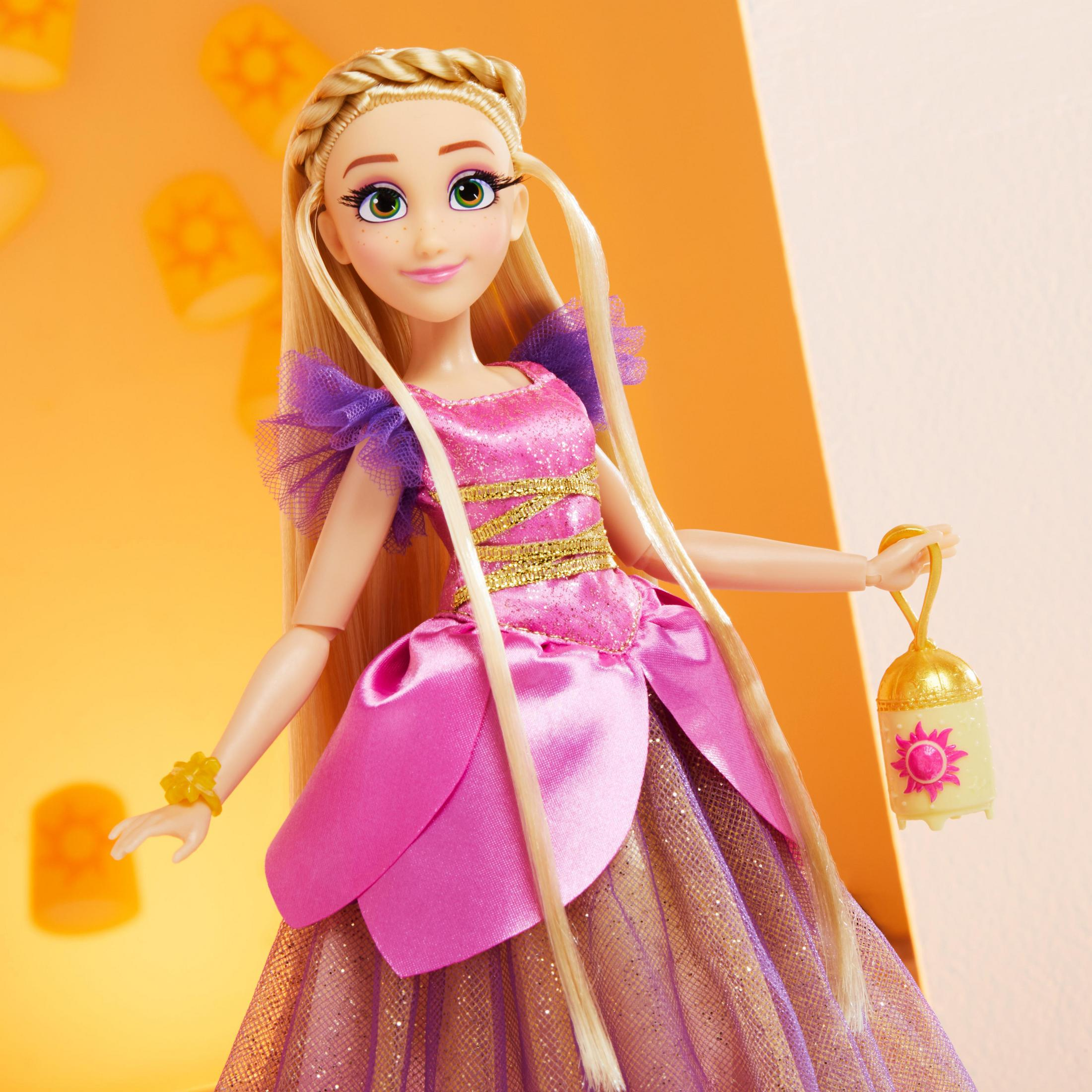 Eine Puppe mit einem rosa und goldenen Kleid, mit langen blonden Haaren und einer Laterne.