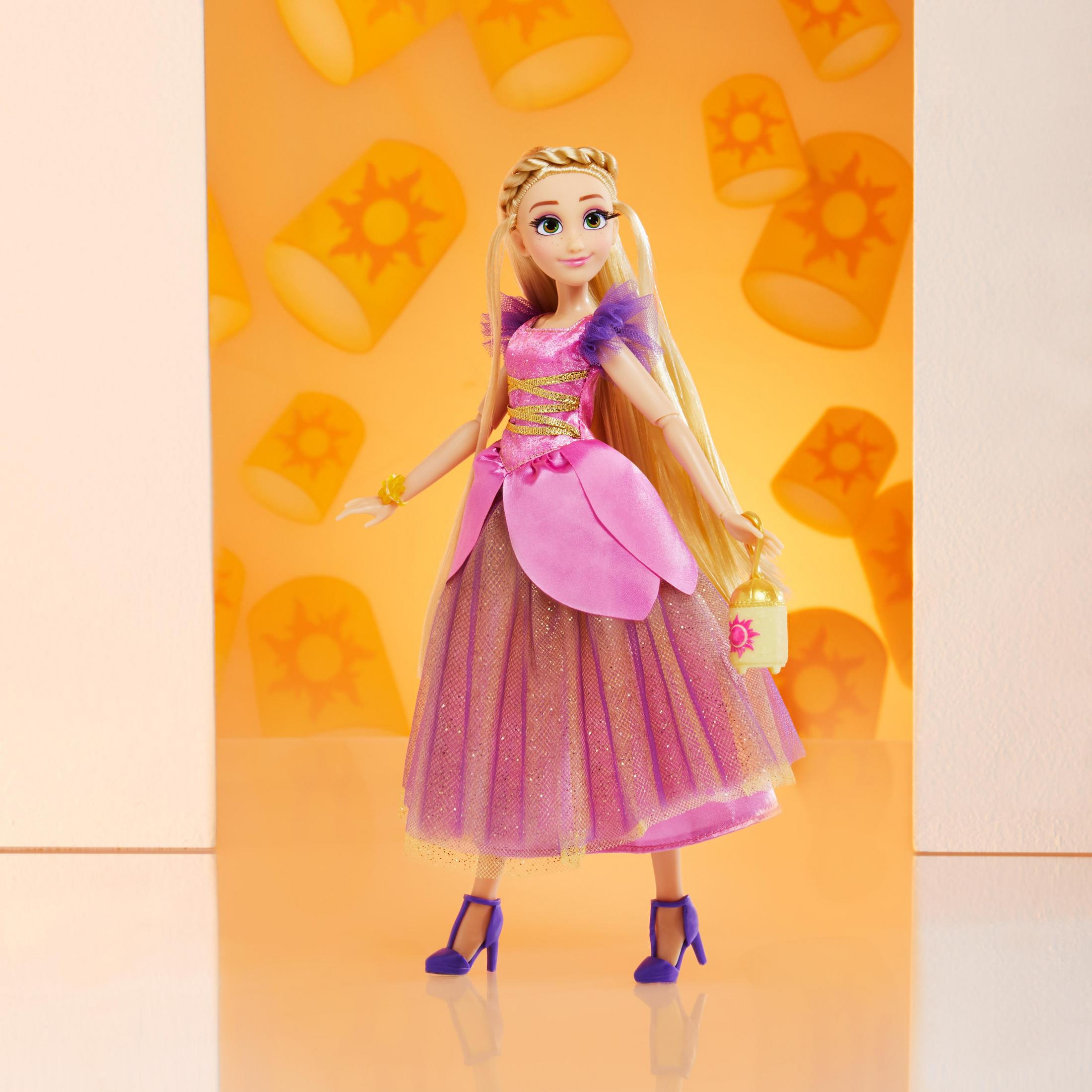 Rapunzel-Puppe in einem rosa Kleid, mit einer Laterne, vor einem gelben Hintergrund mit schwebenden Laternen.